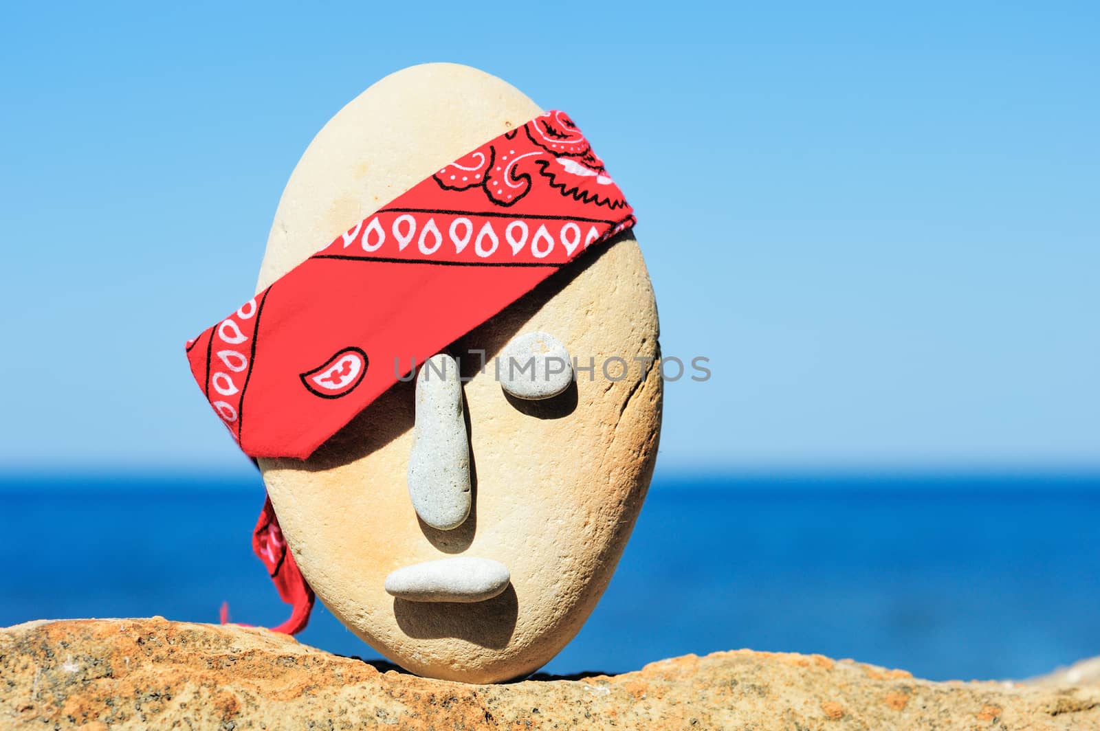 Image of stone head with a patterned red bandana