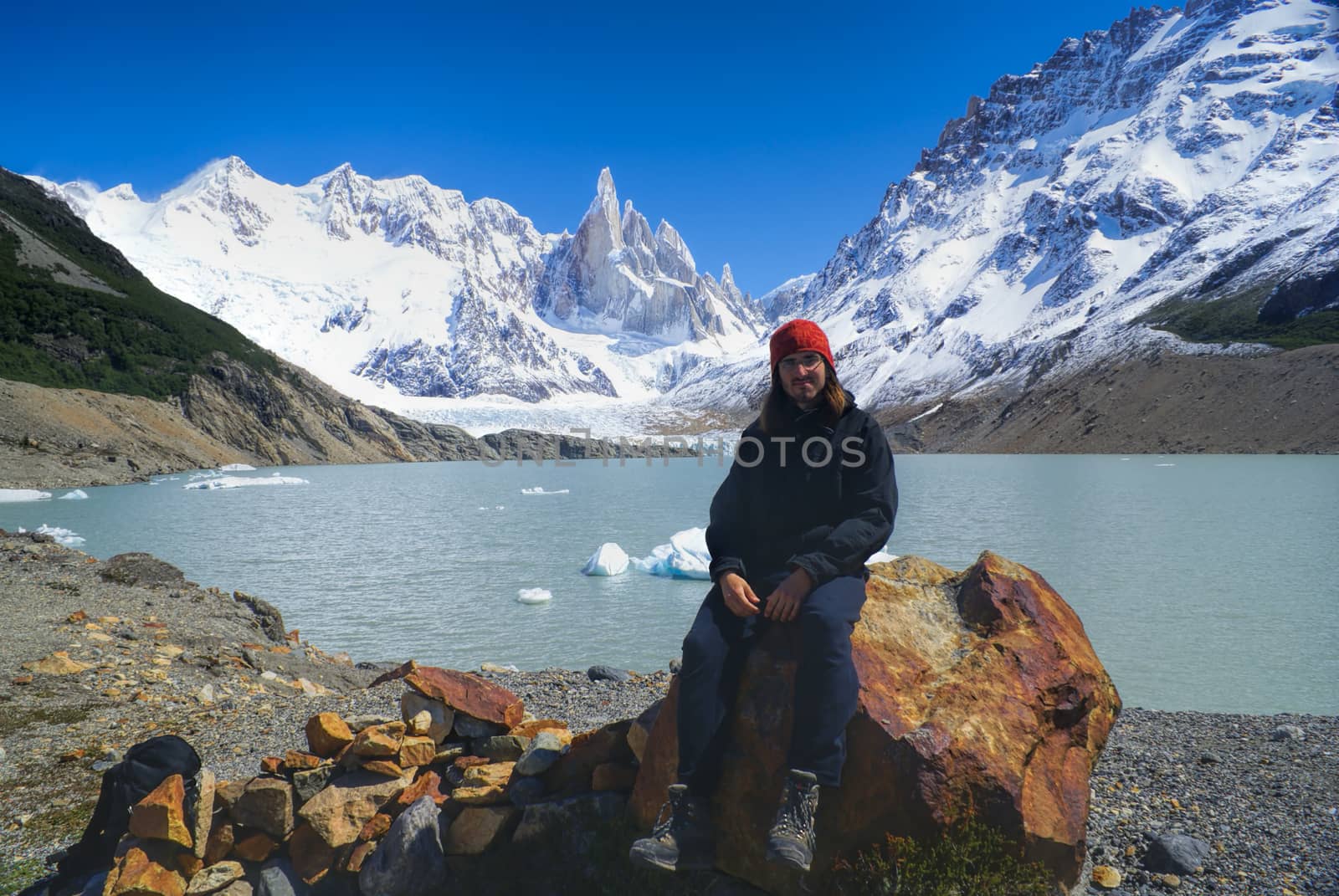 Hiker sitting on a rock on the shore of a lake in Los Glaciares National Park               