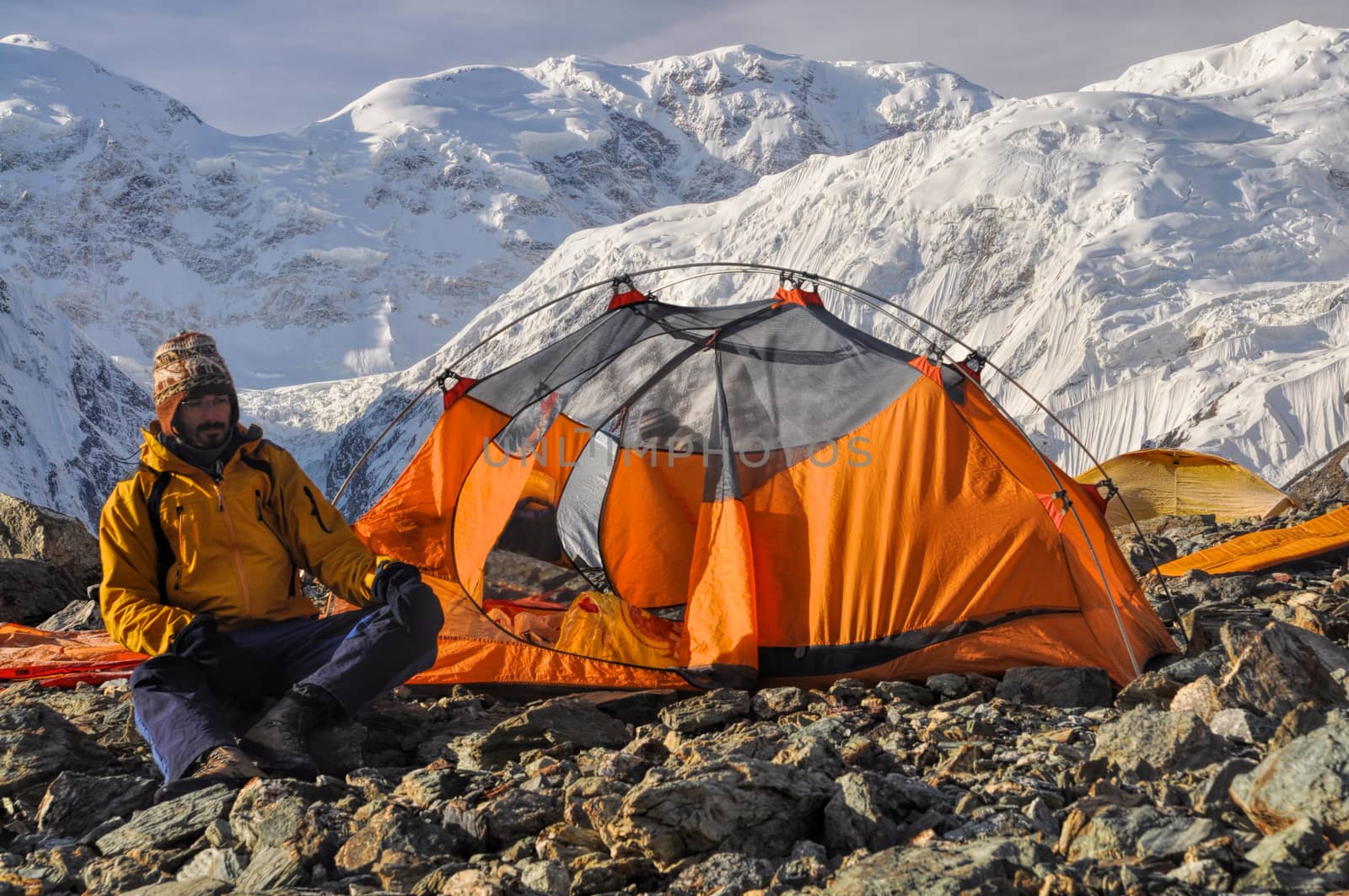 Adventurous hiker camping near Engilchek glacier in scenic Tian Shan mountain range in Kyrgyzstan