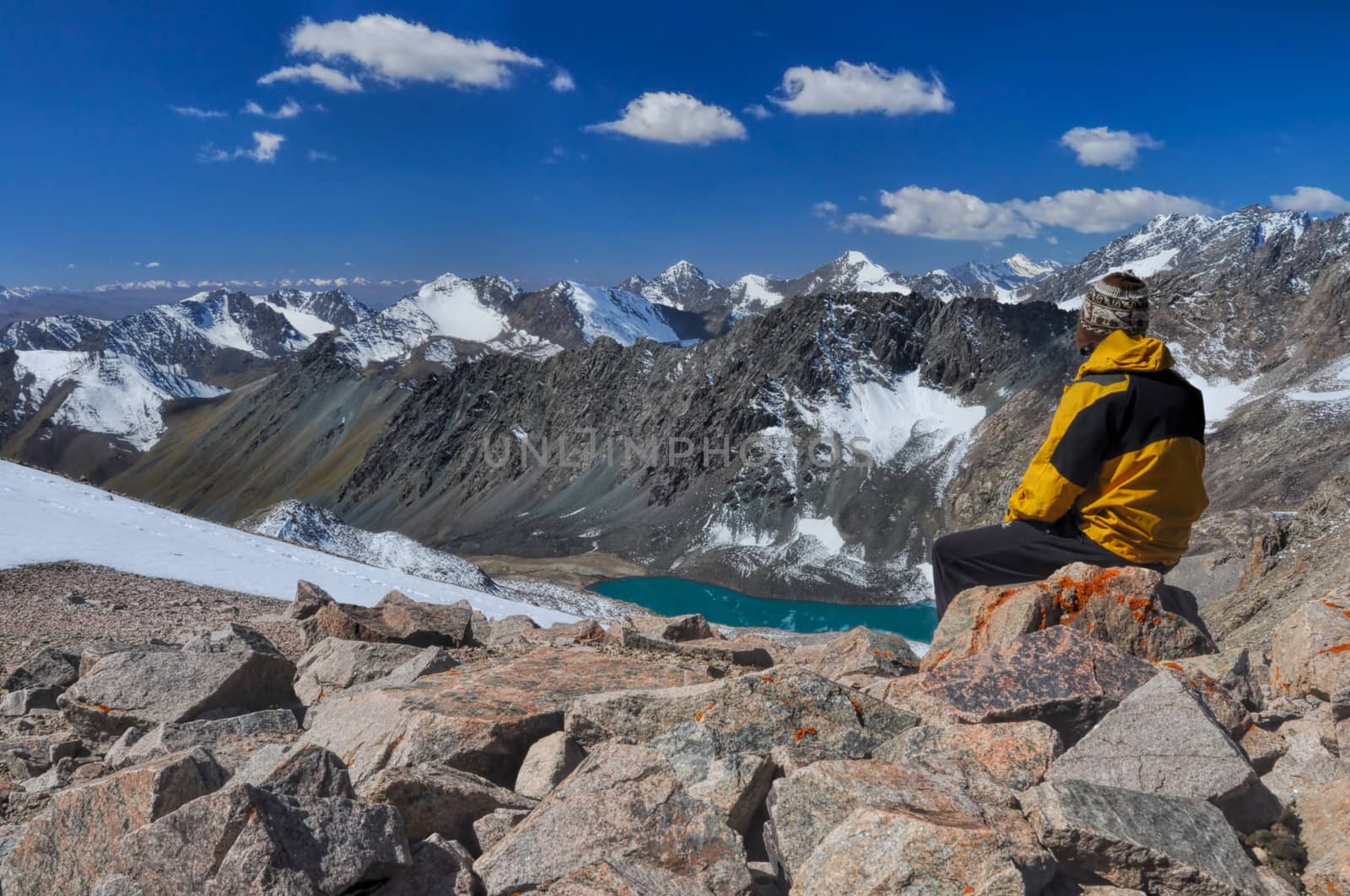 Young hiker on mountain summit in scenic Tian Shan range in Kyrgyzstan, Ala Archa national park