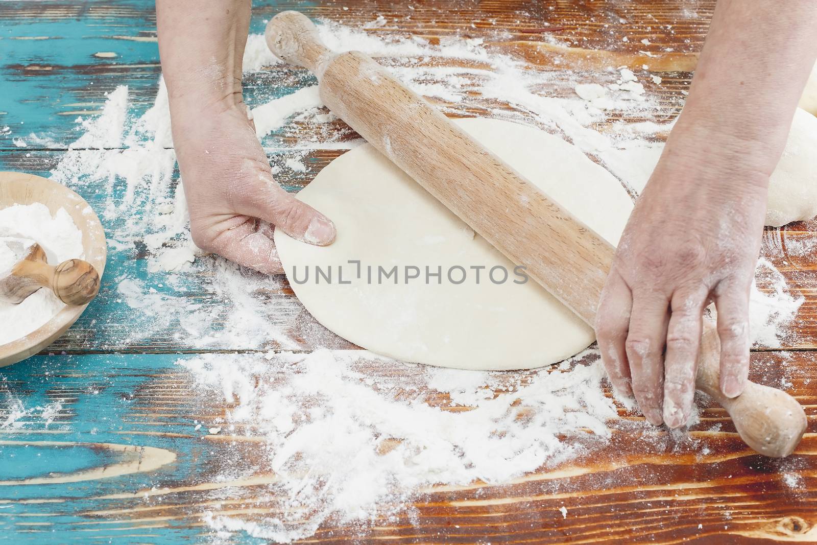 Woman rolling dough using rolling pin by Slast20