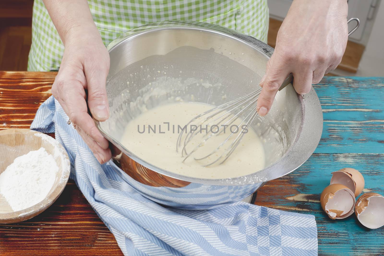 Woman mixing eggs and wheat flour in a bowl