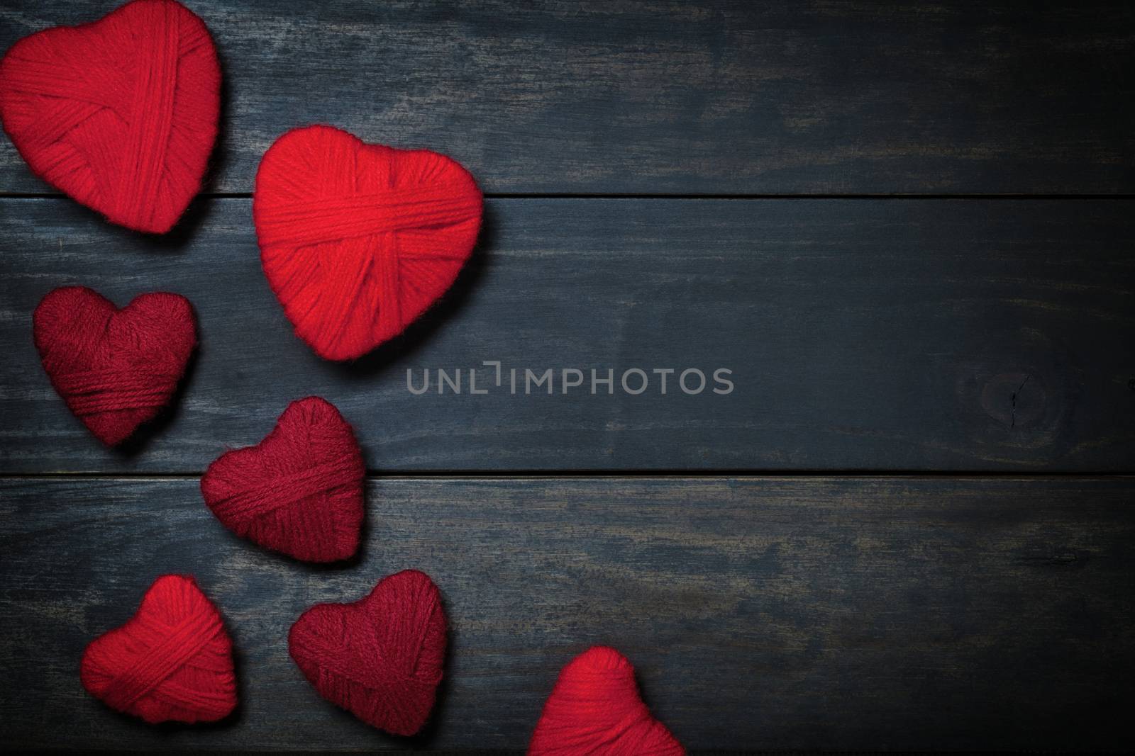 Hearts made of red wool on wooden background for Valentine's Day. Copy space. Top view