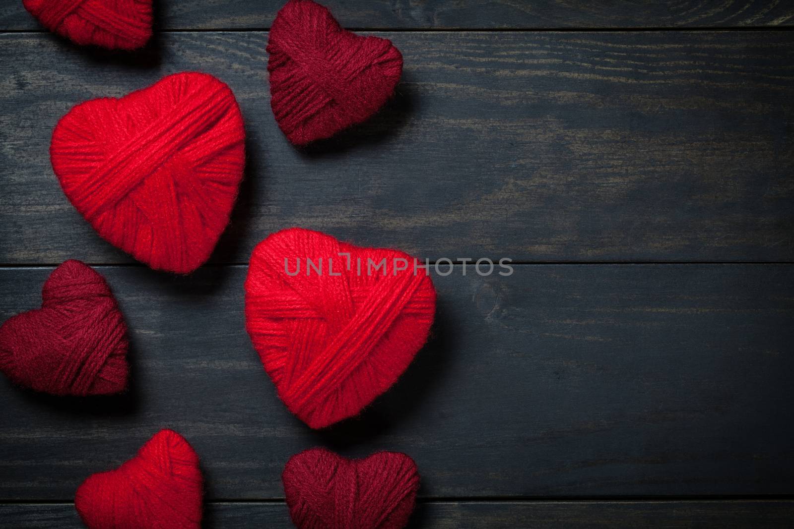 Hearts made of red wool on wooden background for Valentine's Day. Copy space. Top view