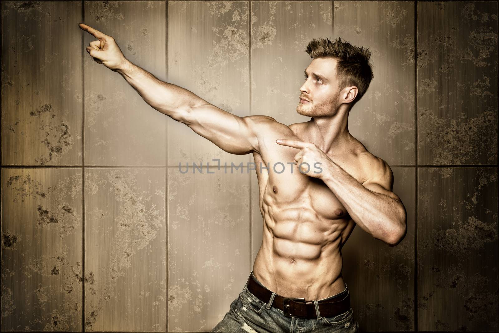 Posing young well trained man with perfect abdominal and pectoral muscle