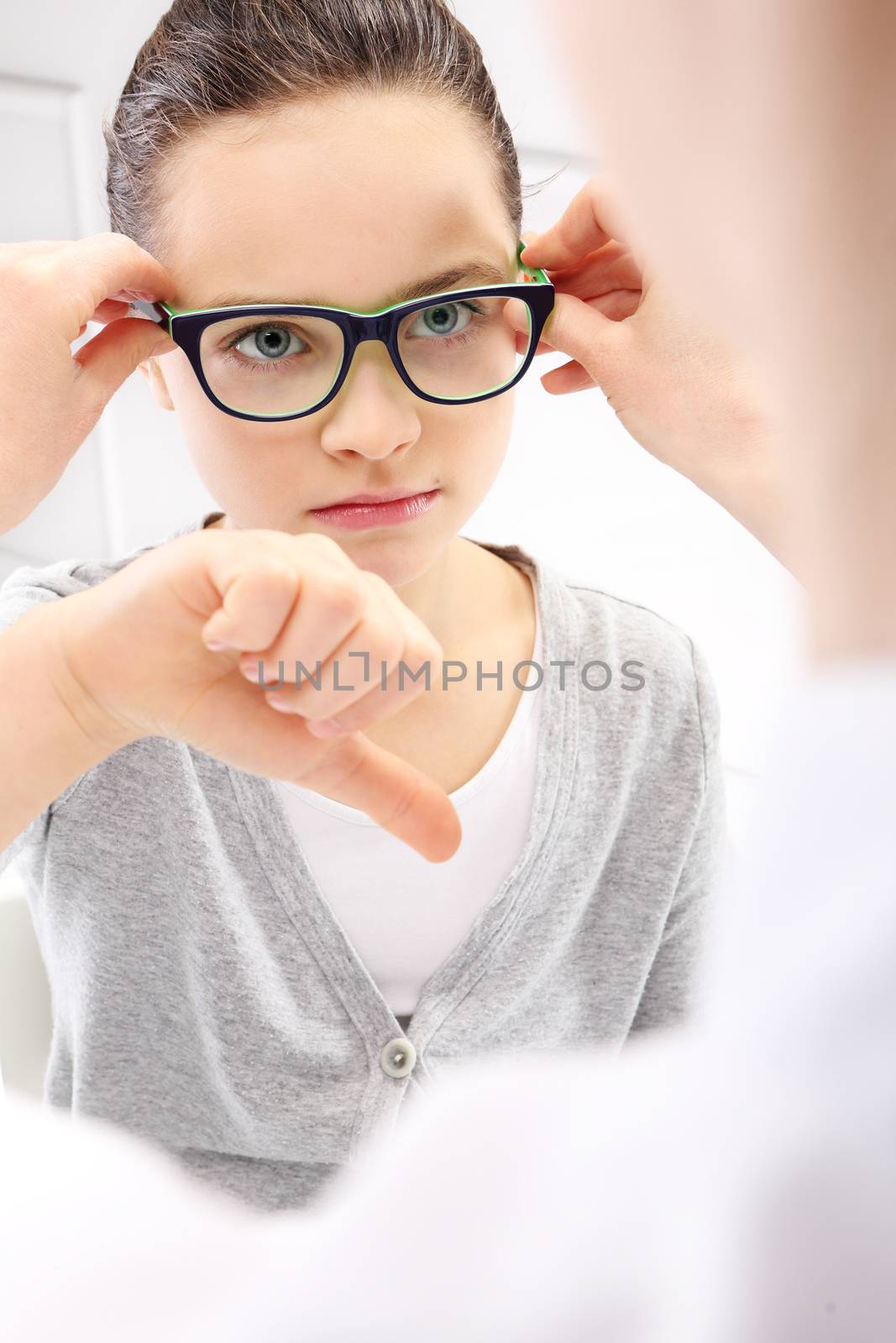 Selection of glasses, a little girl with an ophthalmologist.