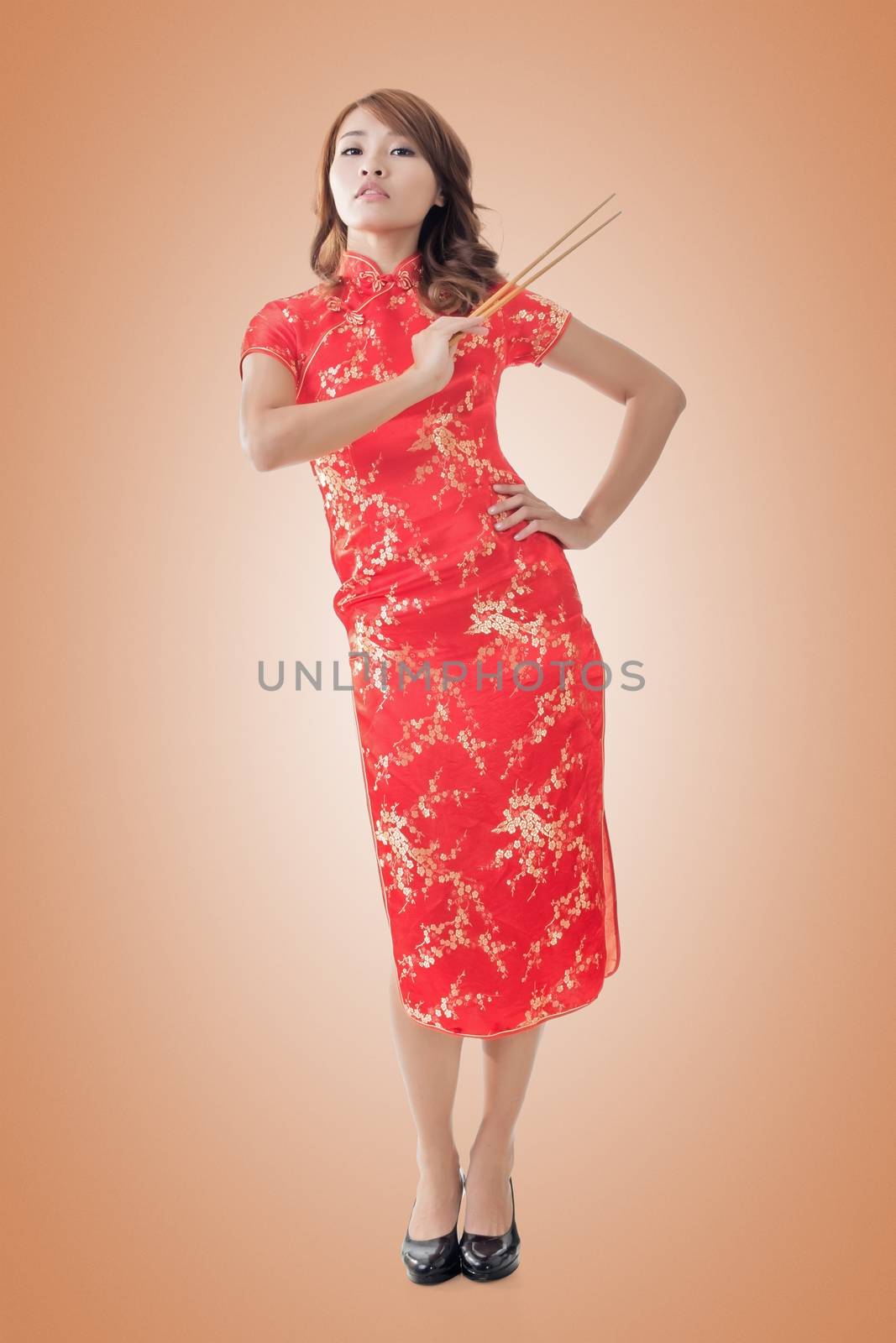 Smiling Chinese woman dress traditional cheongsam standing and holding chopsticks at New Year, full length portrait isolated.