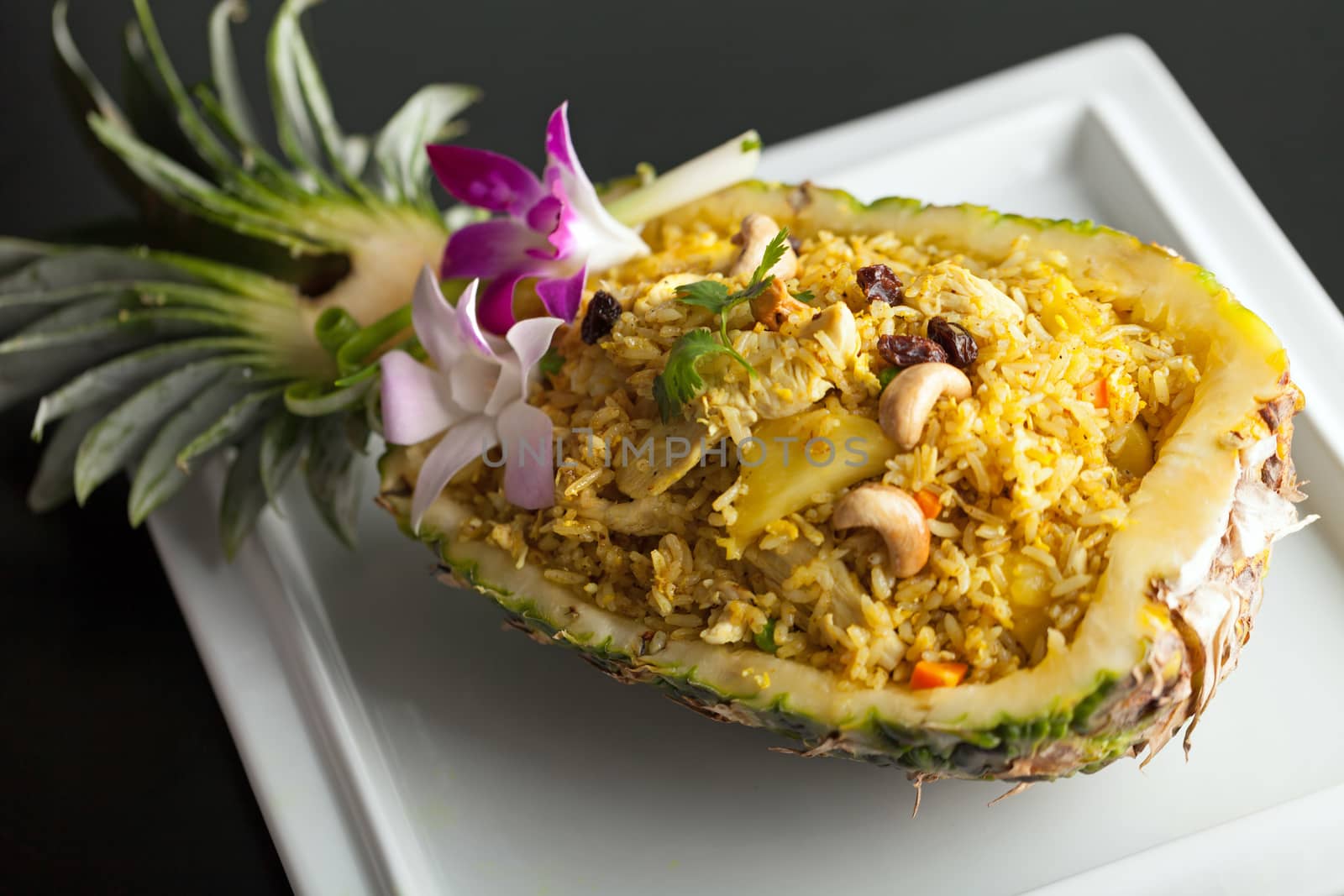 Freshly prepared pineapple fried rice served inside of a pineapple carved like a bowl.