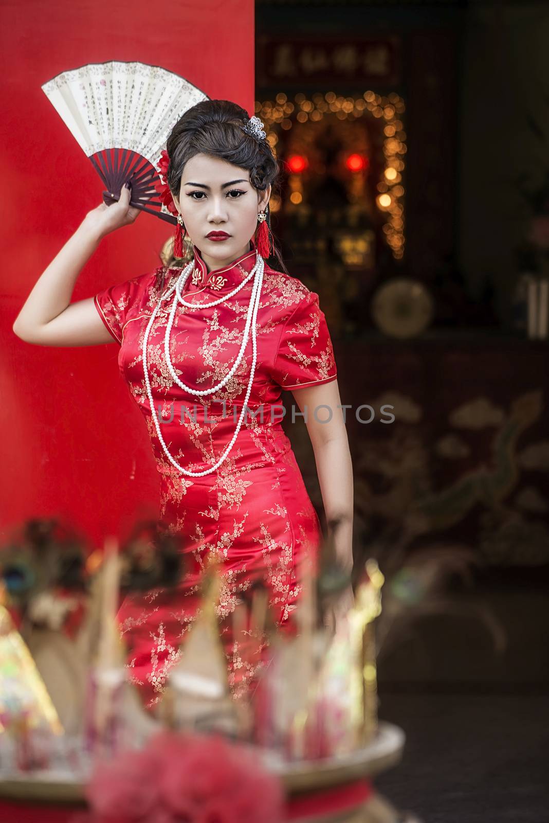 Chinese woman red dress traditional cheongsam ,close up portrait with red wood door