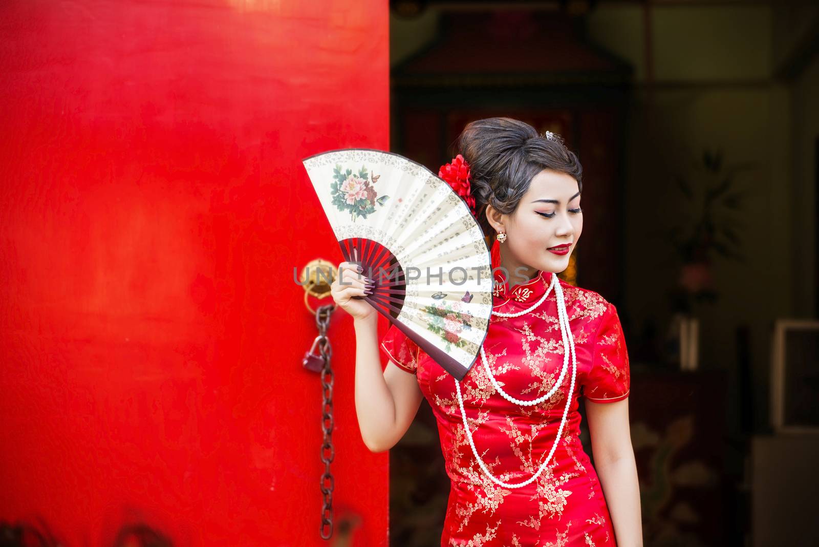 Chinese woman red dress traditional cheongsam ,close up portrait with red wood door
