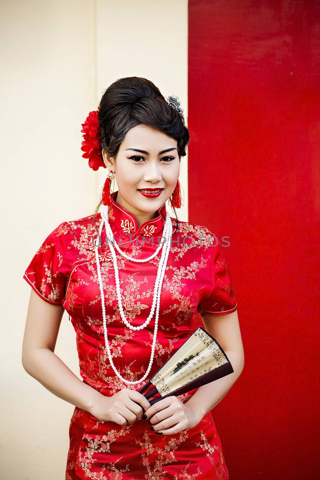 Chinese woman red dress traditional cheongsam ,close up portrait with red wood door