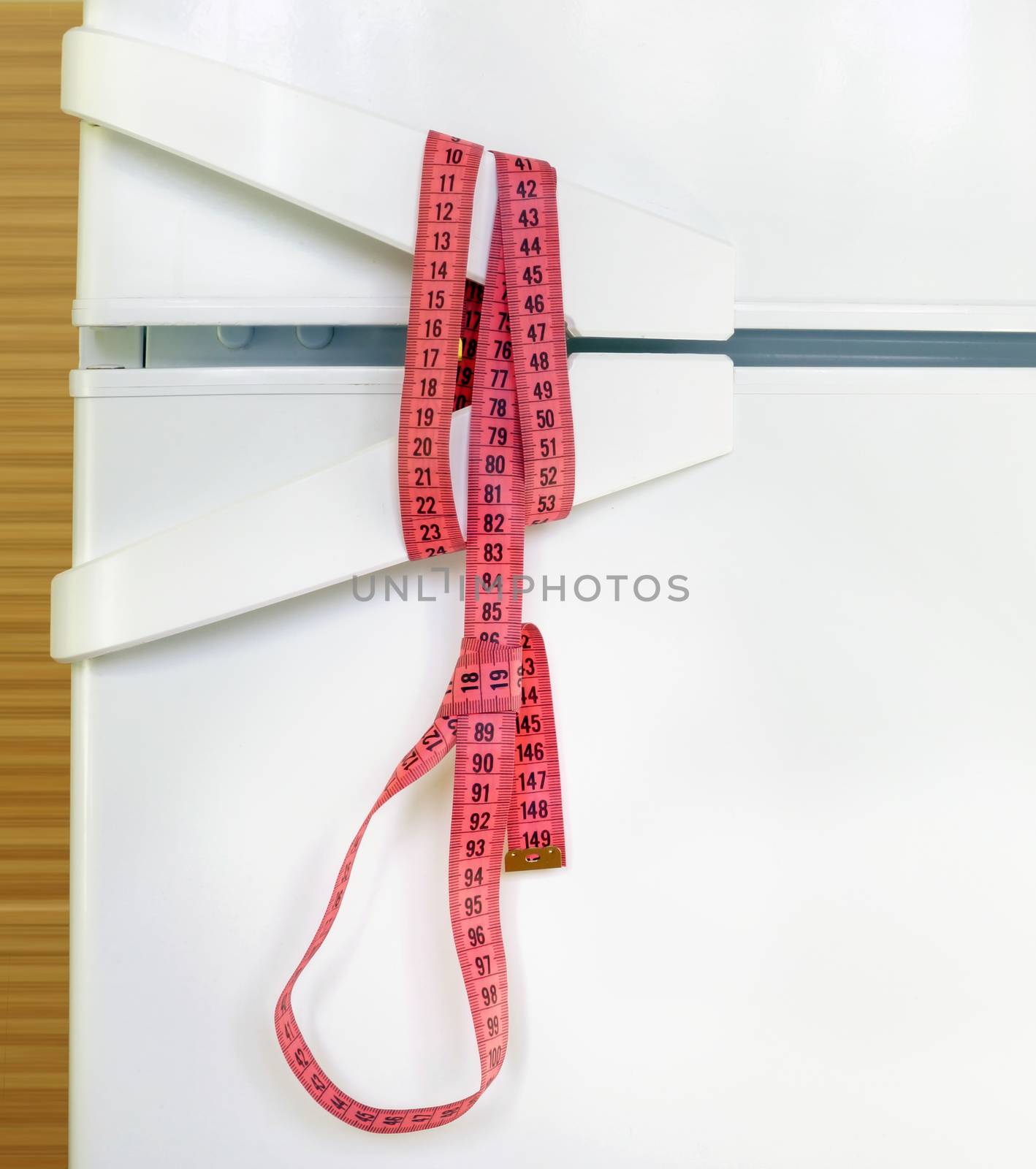 Measuring tape noose on refrigerator door. Diet and anorexia concept