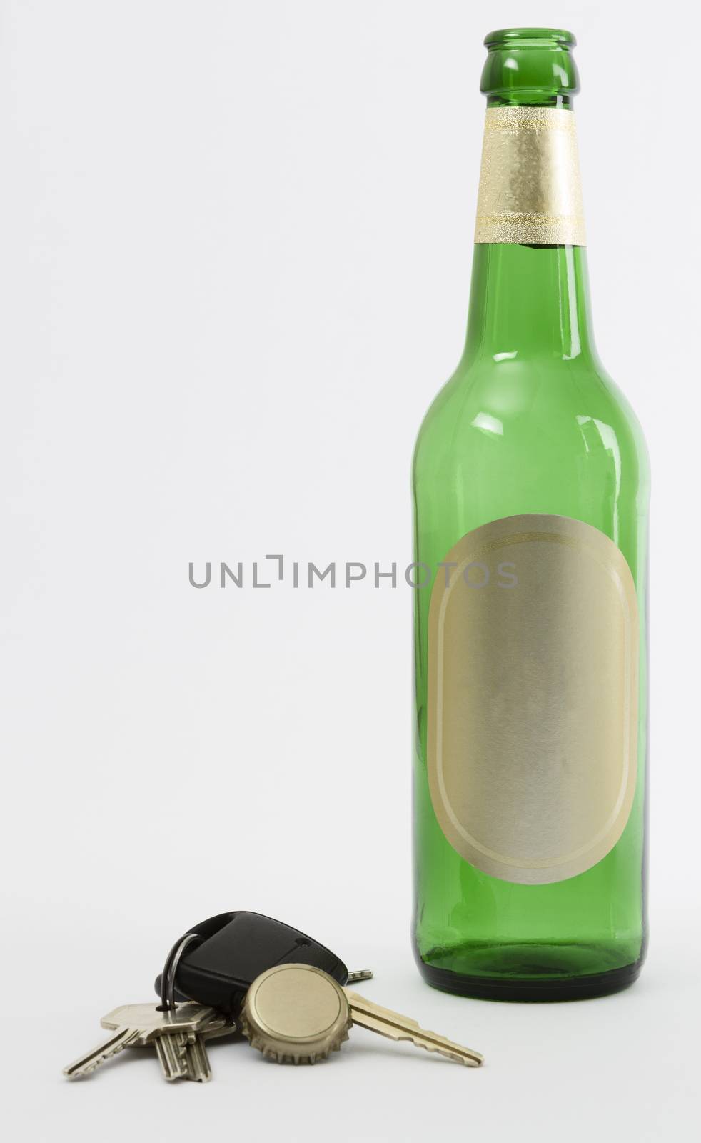 empty beer bottle with car key and crown cork isolated in grey background.