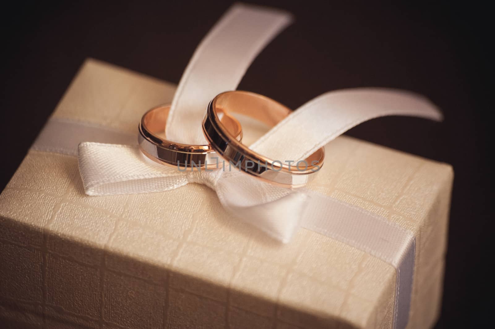 two wedding rings placed on white bow