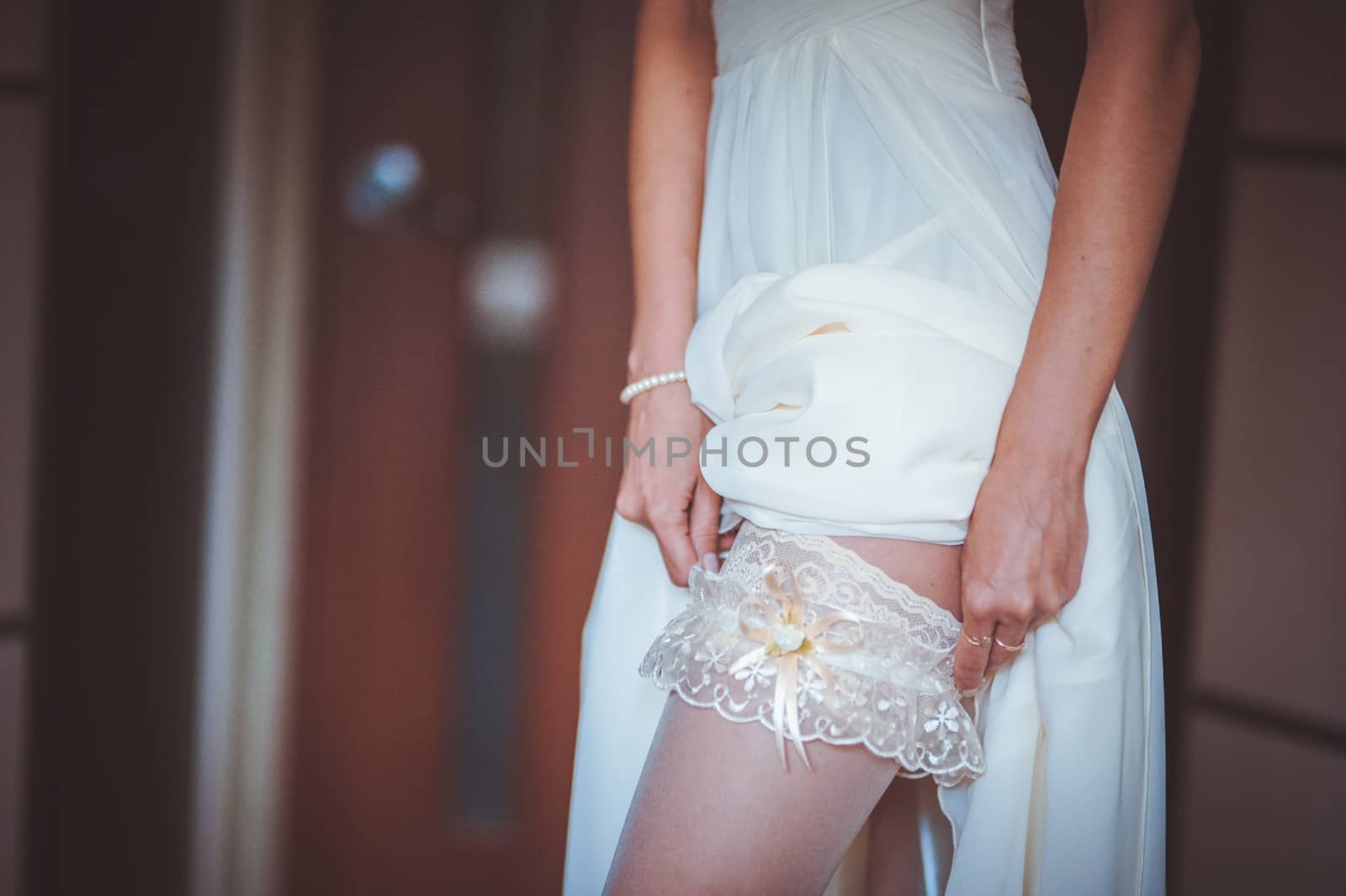 bride putting on white garter no face seen 