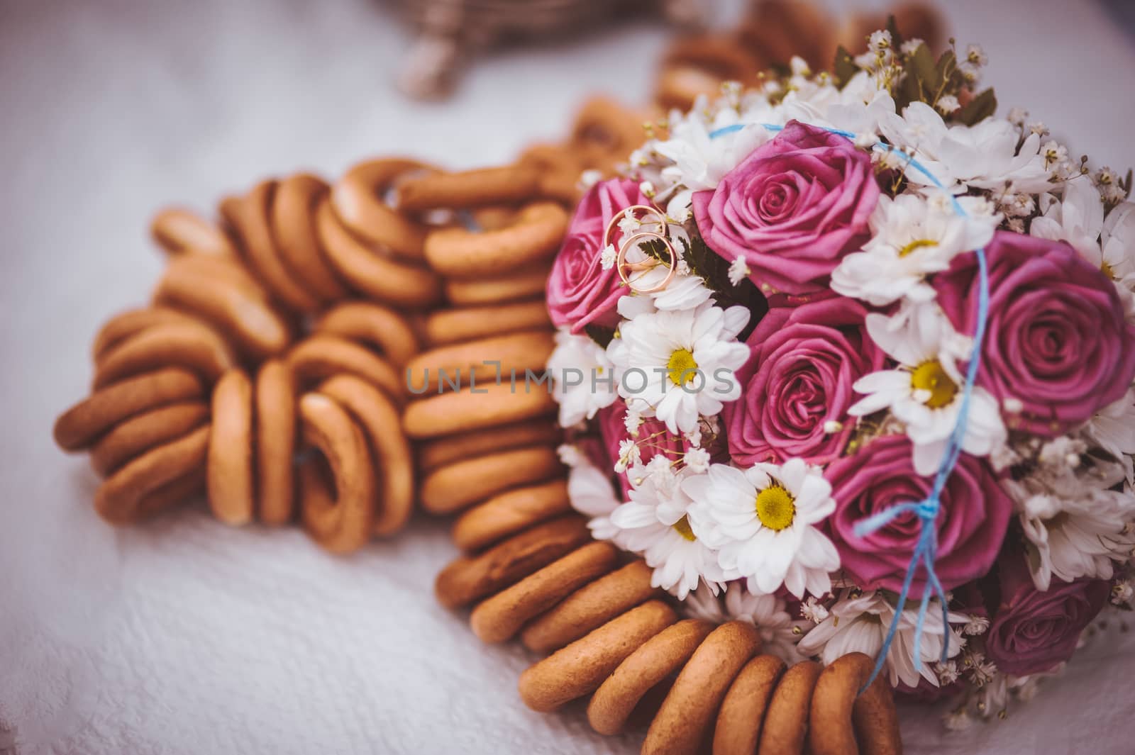 pink and white wedding bouquet next to russian bagels 