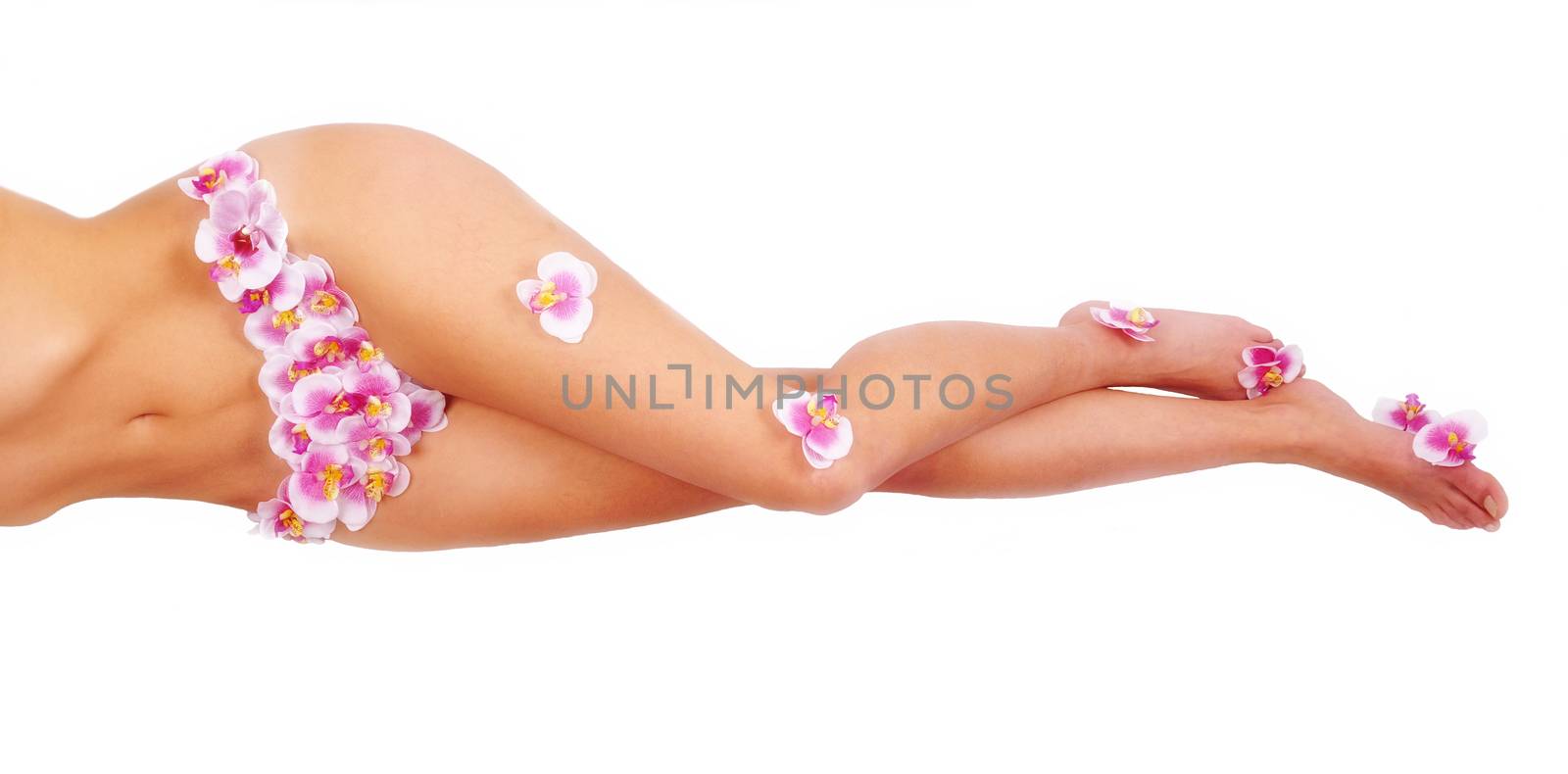 Beautiful  feet of young girl in shorts with an orchid