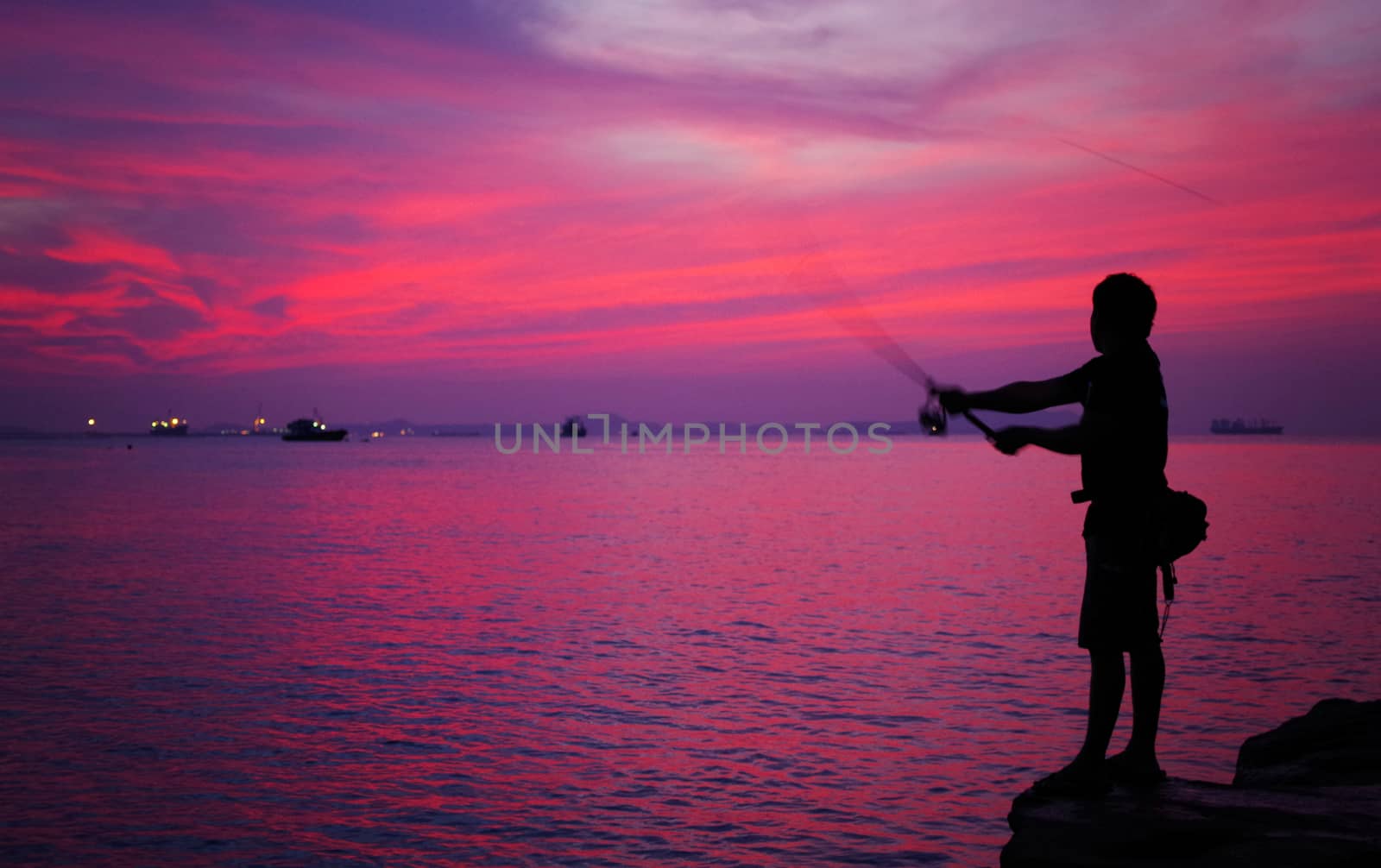 Silhouette of man fishing  beside the sea