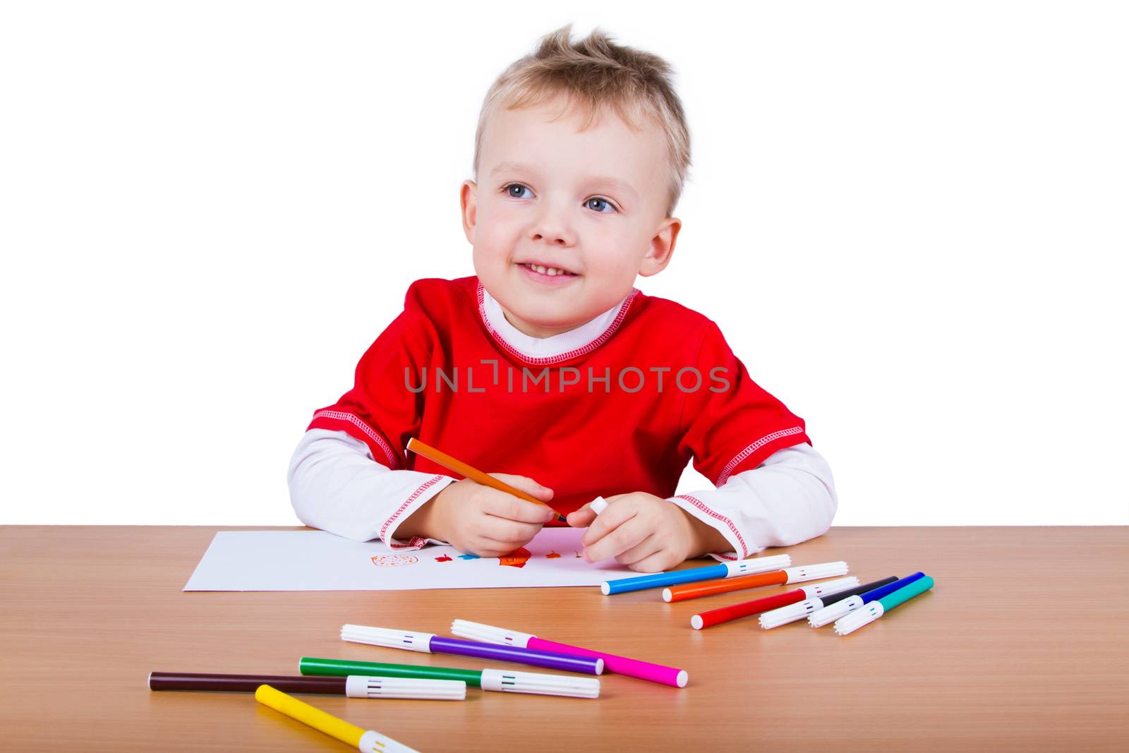 Small boy draws at the table. Isolatad on a white background