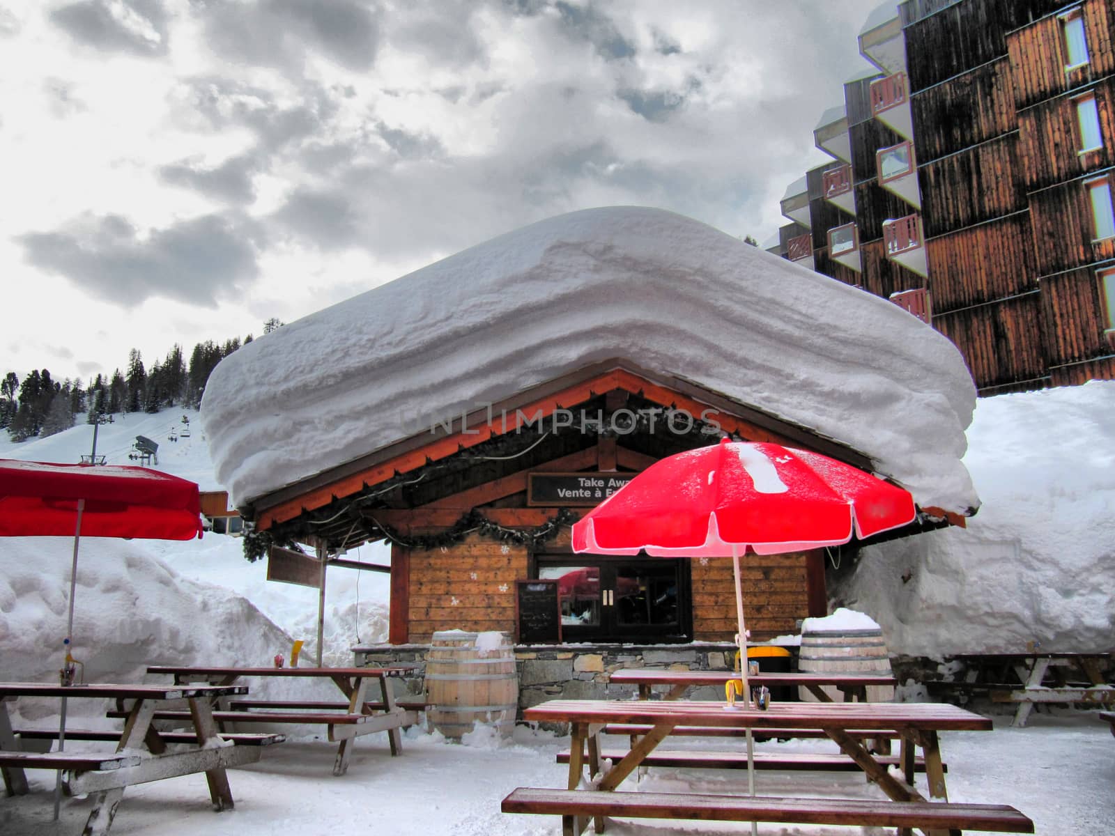 deep snow on the roof of a mountain chalet cabin in la plagne by chrisga