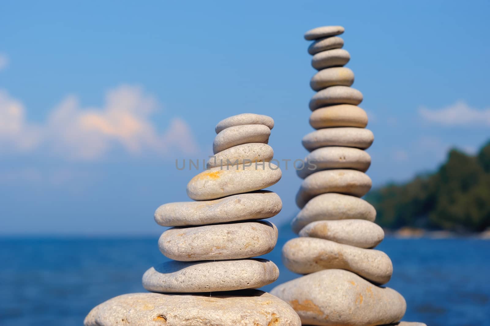 Balancing white piles of pebbles on the seashore