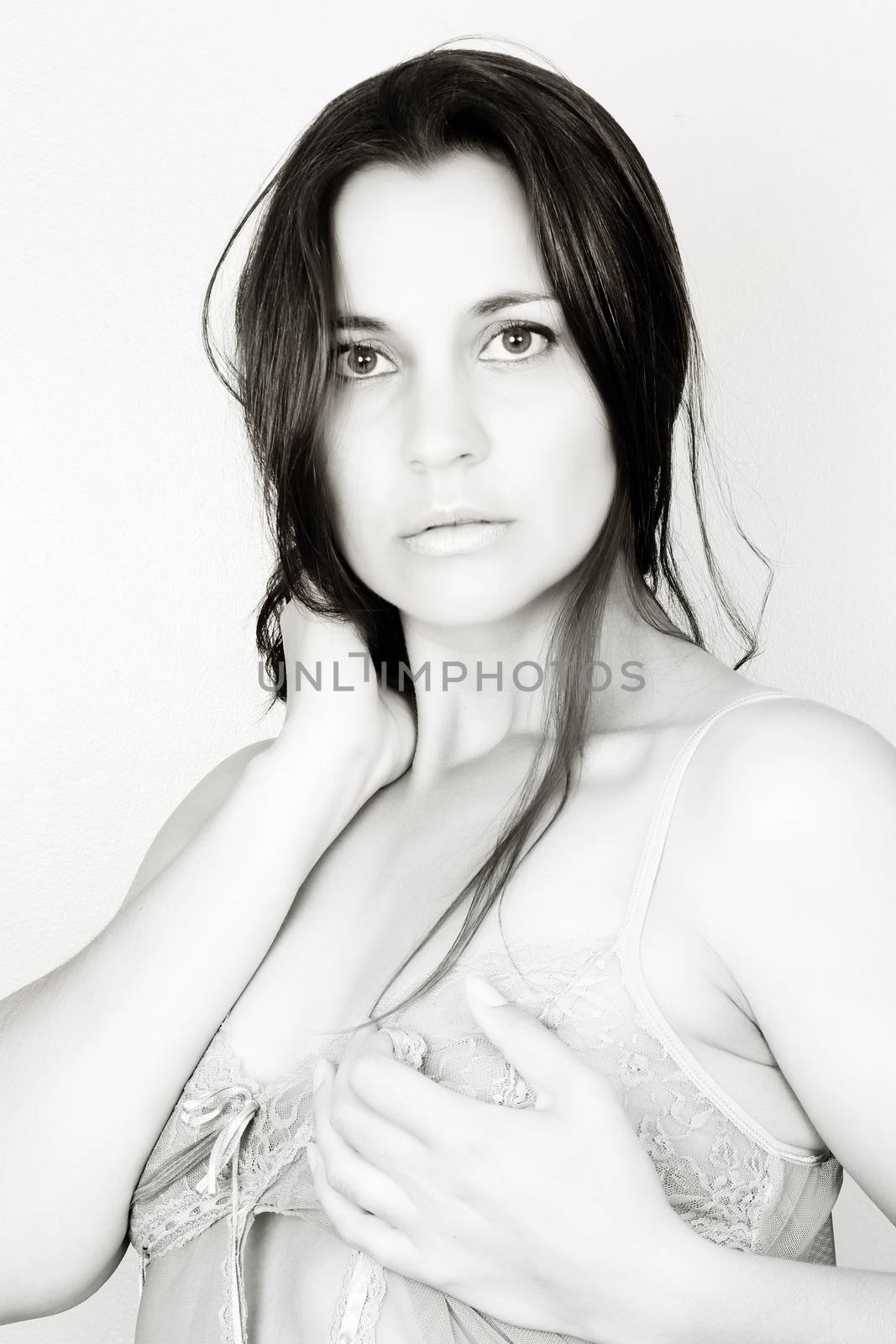 Brunette female wearing lace lingerie against light background