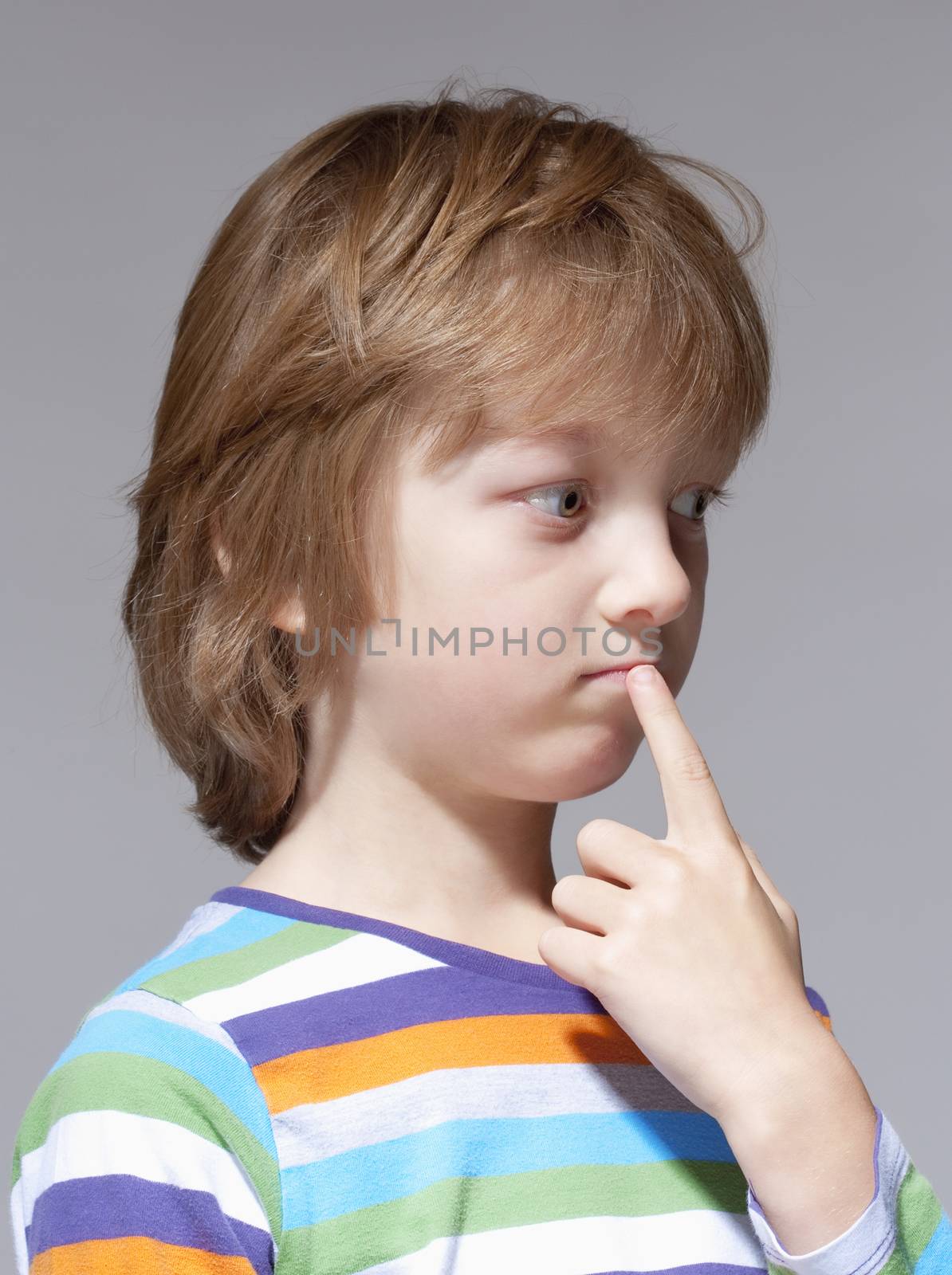 Portrait of a Boy with Blond Hair Thinking, Finger in his Mouth