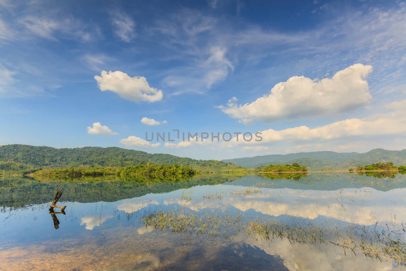 Tropical lake under blue cloudy sky. by ngungfoto
