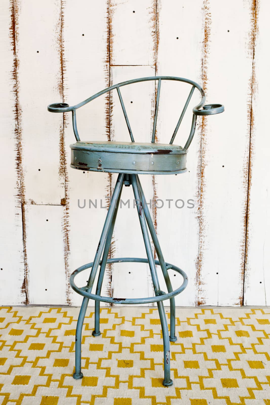 Vintage stool with white wooden background.