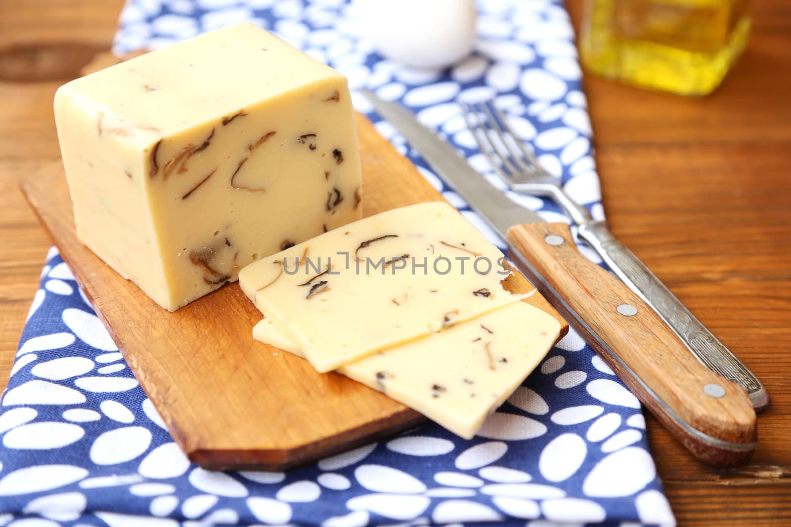 cheese with mushrooms,near the egg,oil on wooden plate