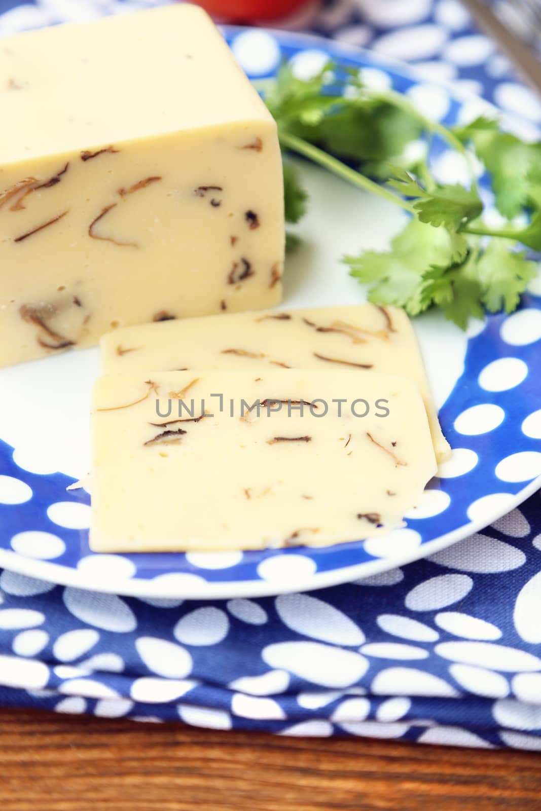 cheese with mushrooms,near the red tomatoes on wooden plate