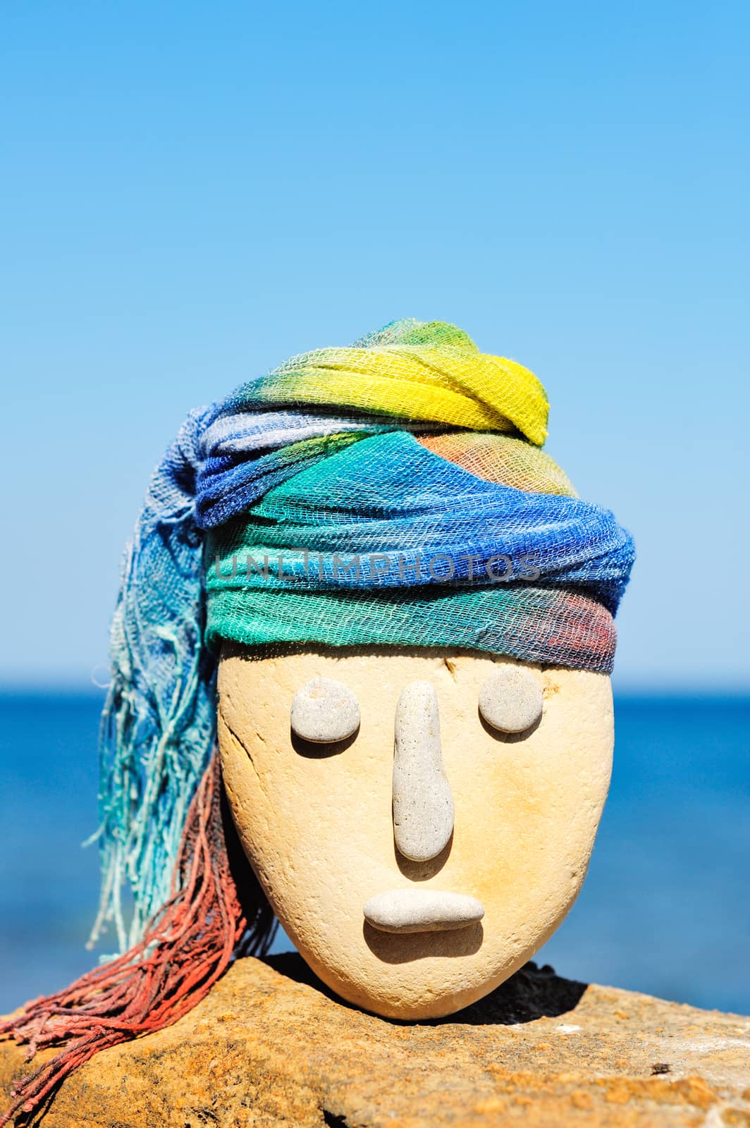 Image of stone head with a coloured bandana