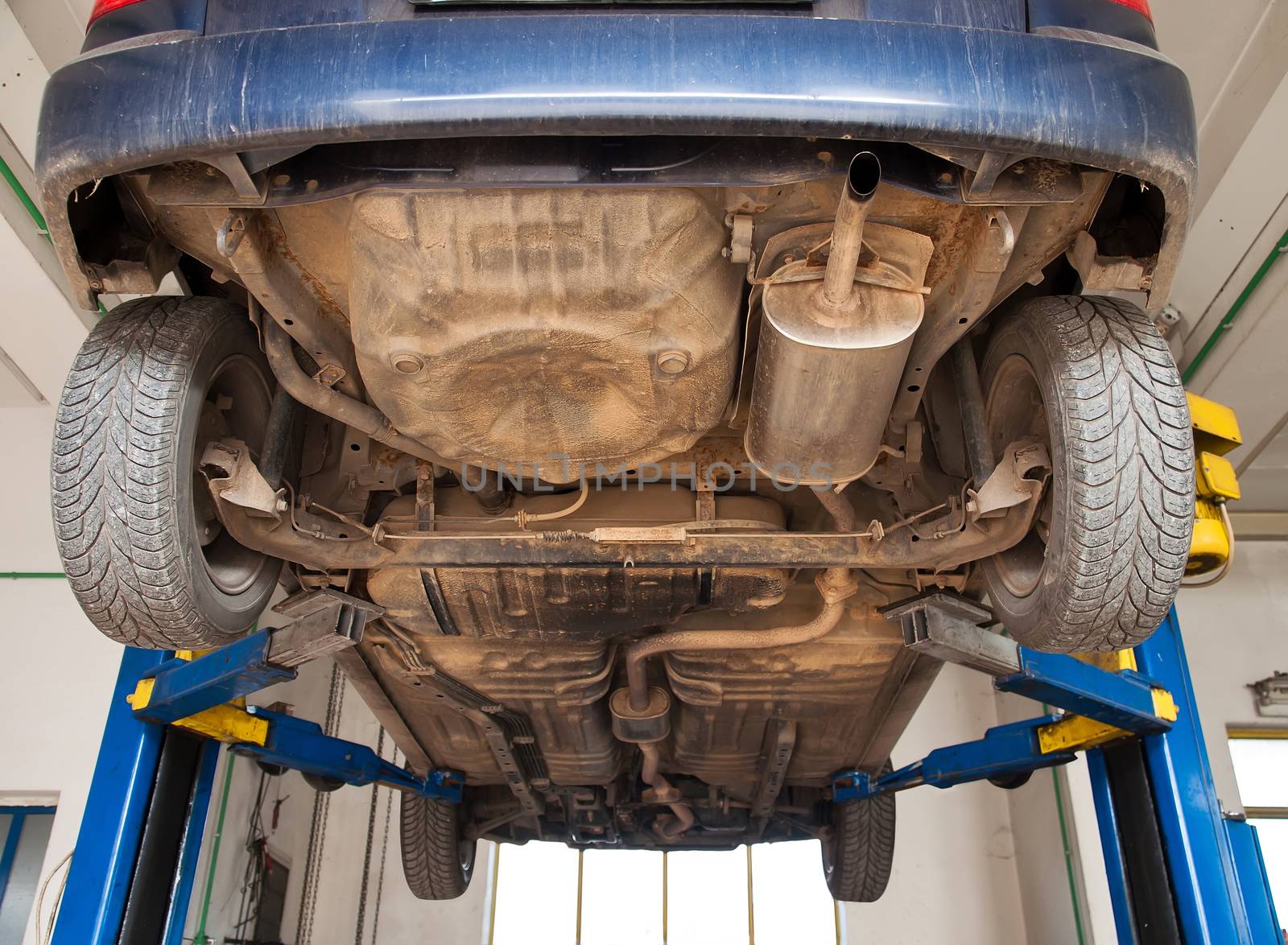 car lifted on repair stand in mechanic garage