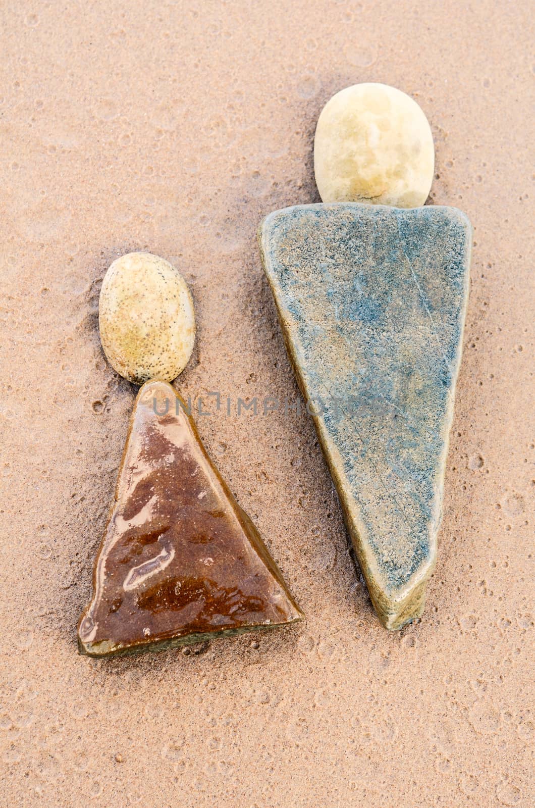 Two triangle stones on the sandy shore