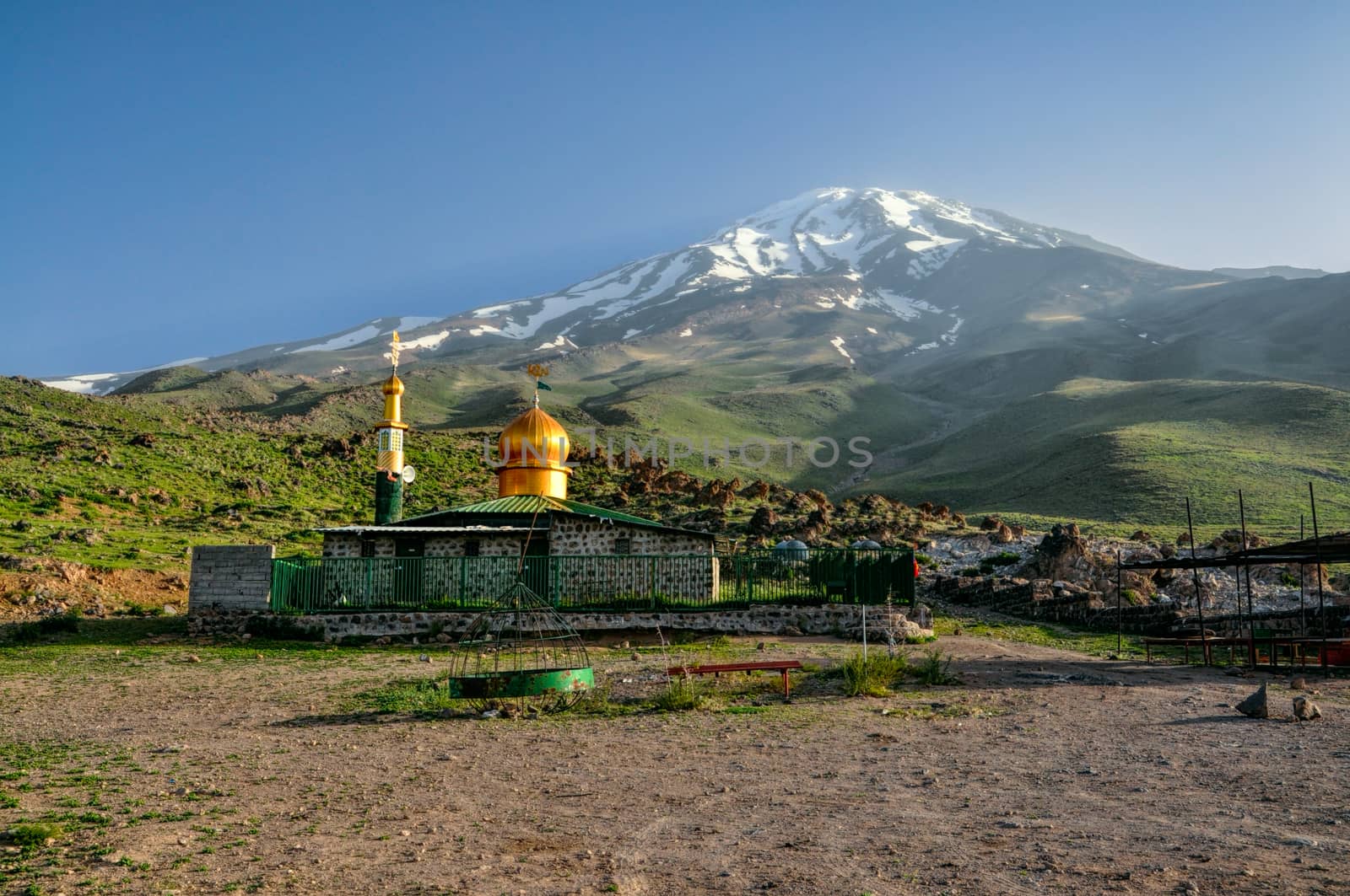 Mosque with golden roof underneath volcano Damavand, highest peak in Iran