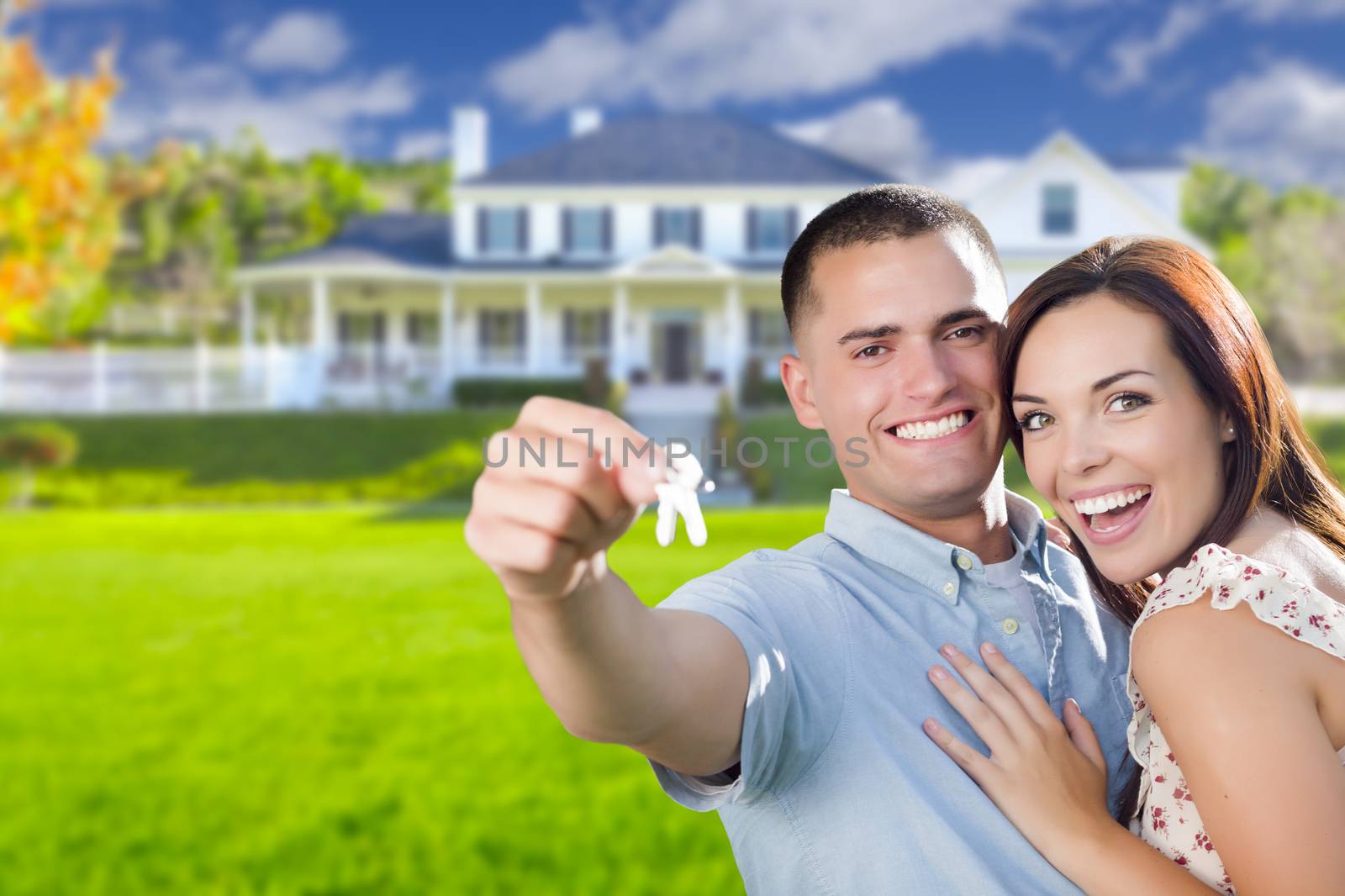 Mixed Race Excited Military Couple In Front of New Home Showing Off Their House Keys.