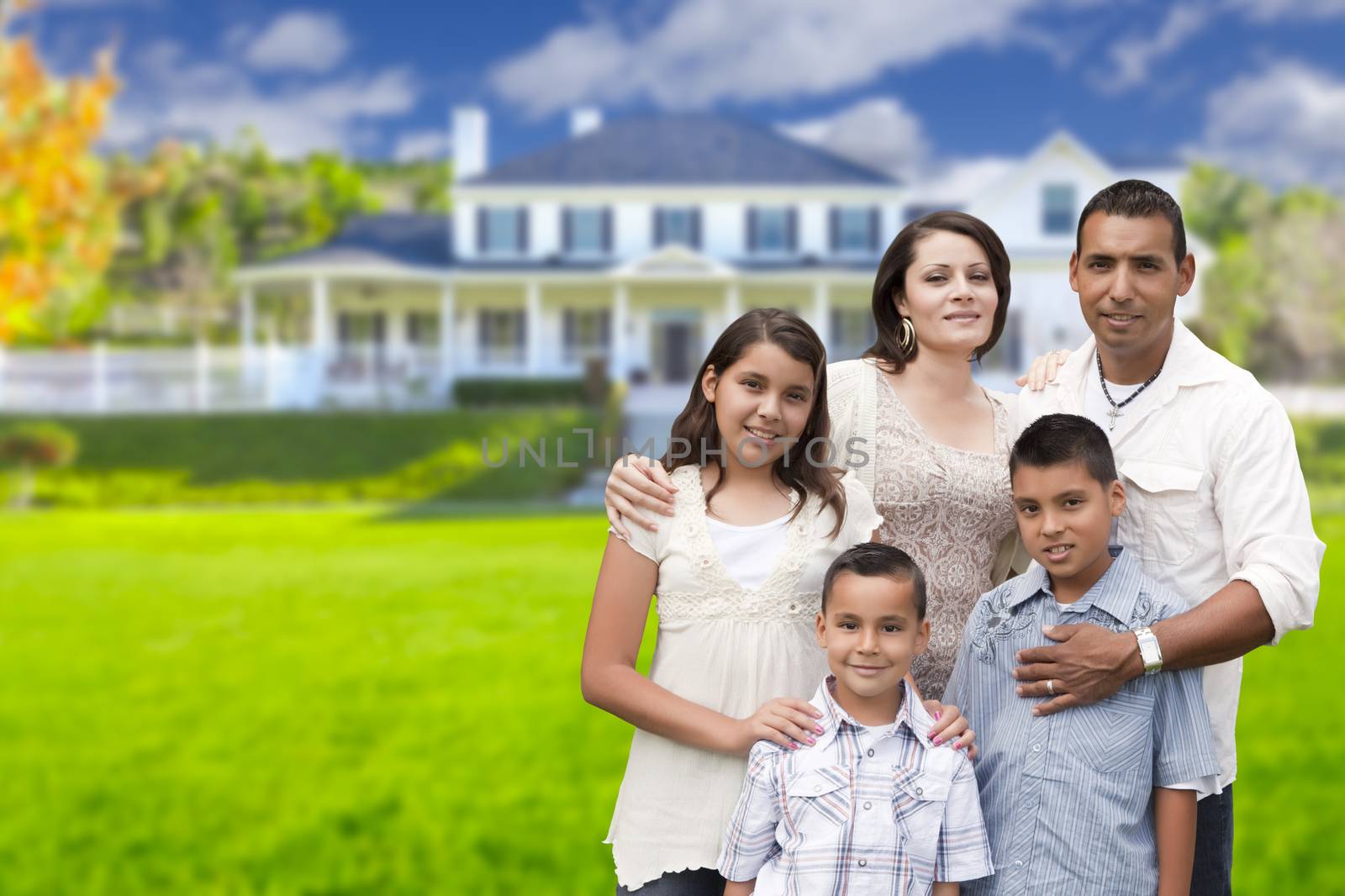 Young Hispanic Family in Front of Their New Home by Feverpitched