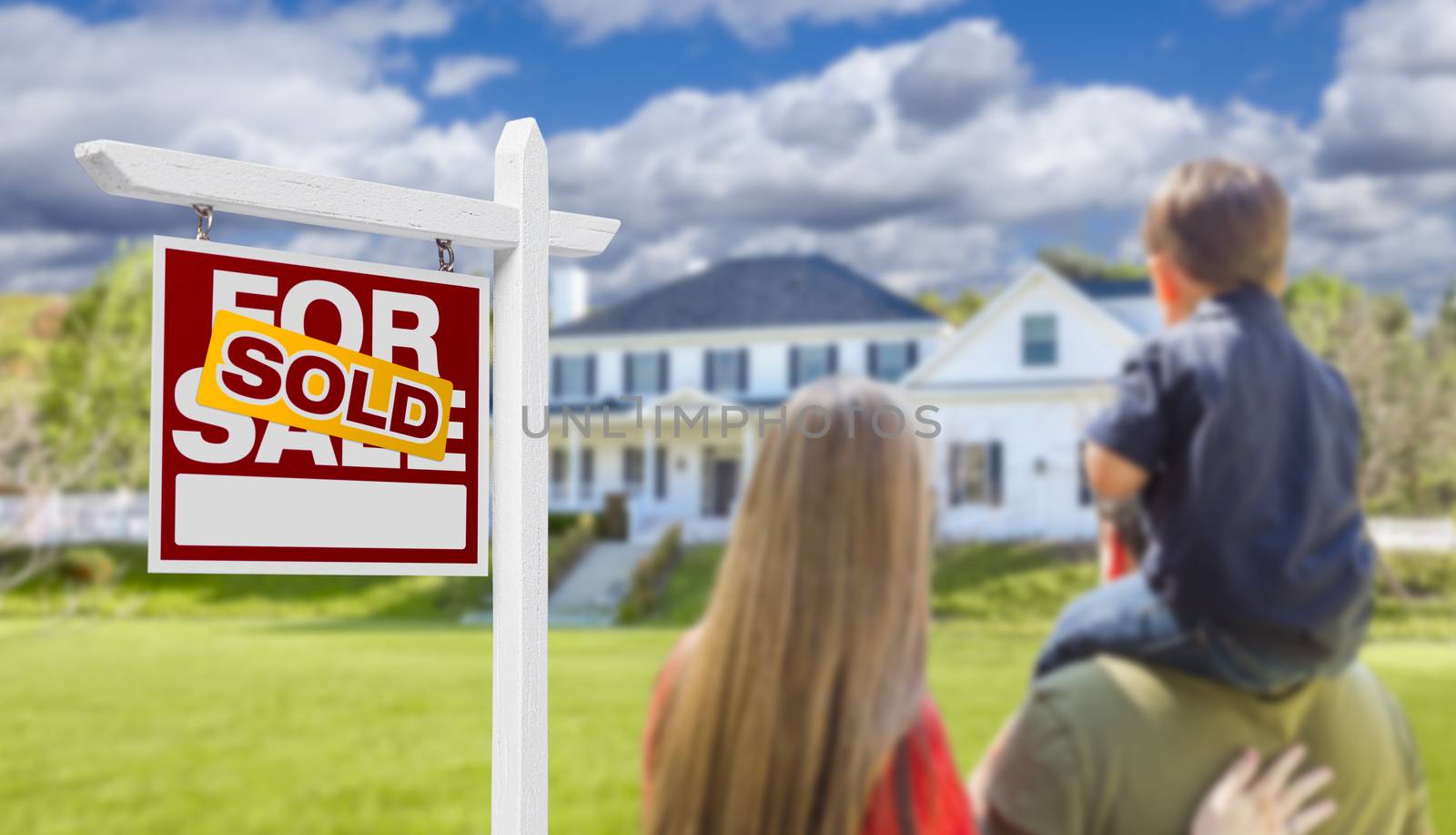 Curious Family Facing Sold For Sale Real Estate Sign and Beautiful New House.