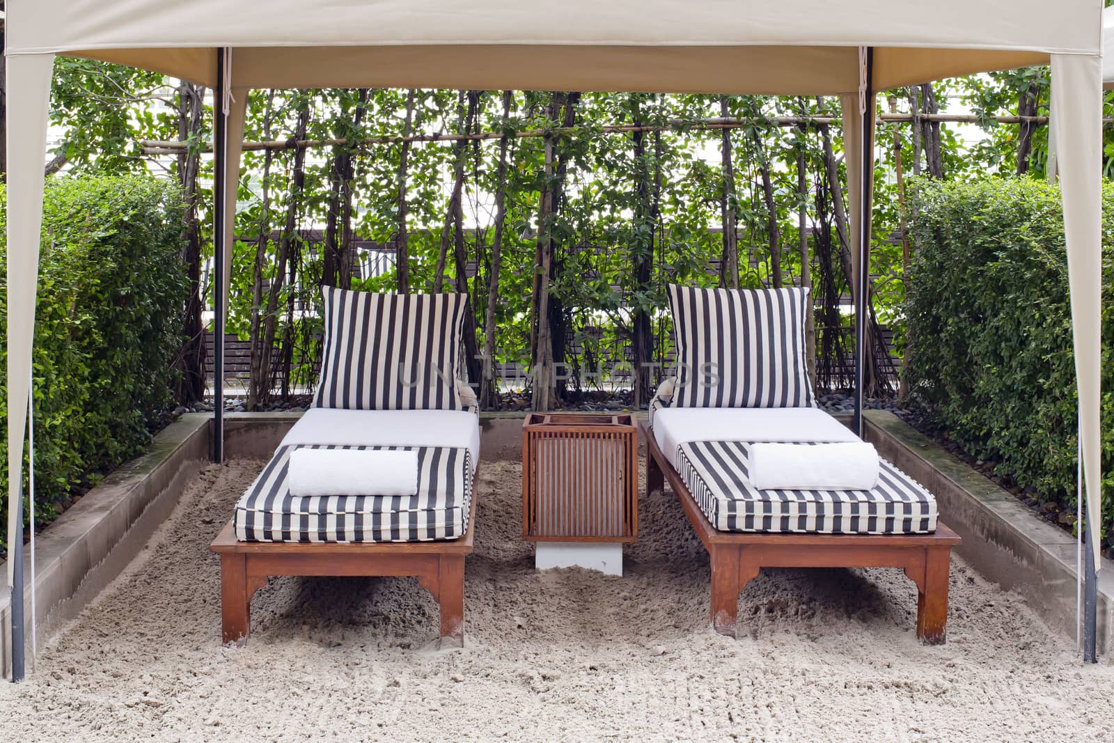 Beach chair and big umbrella on sand beach. Concept for rest, relaxation, holidays, spa, resort.