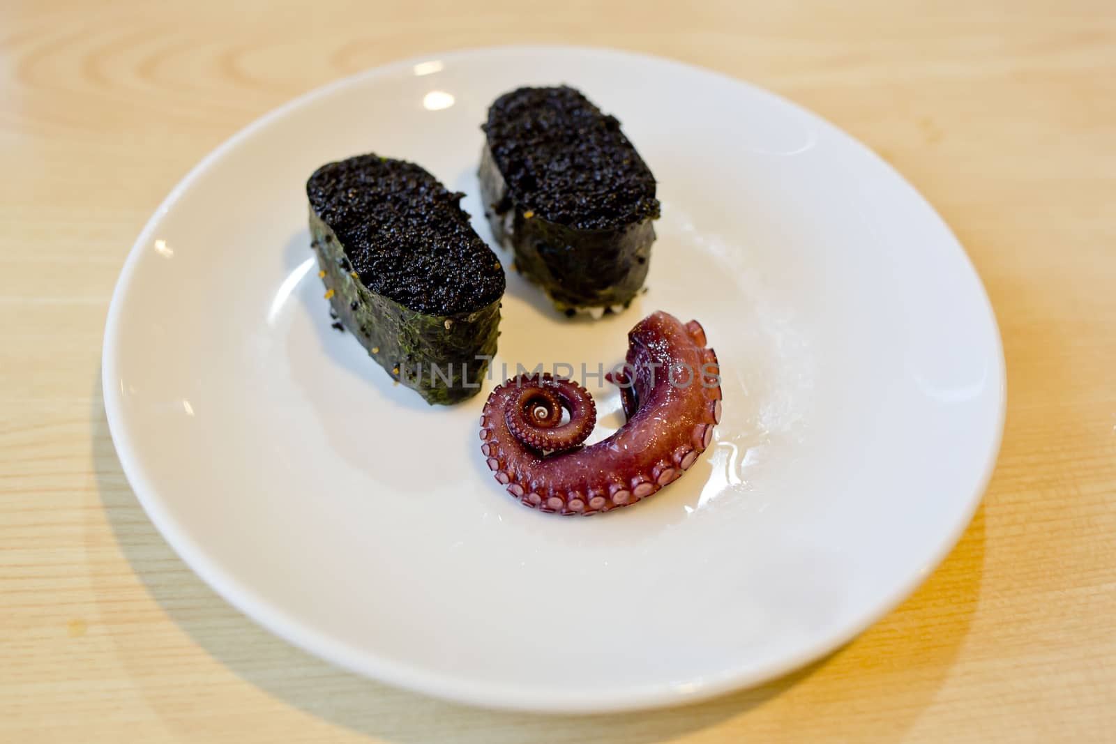 Japanese cuisine Maki Sushi with black caviar and octipus. display on white dish in smile charactor.