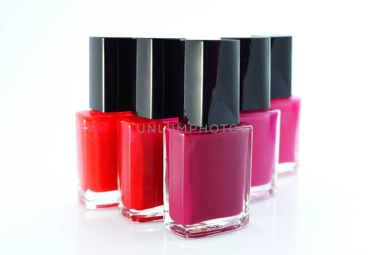 Bottles with red nail polish over white background