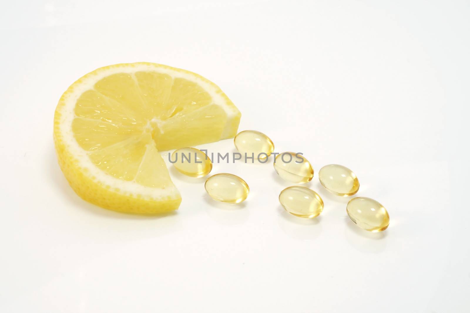 Lemon slice with yellow vitamin pills - vitamin concept