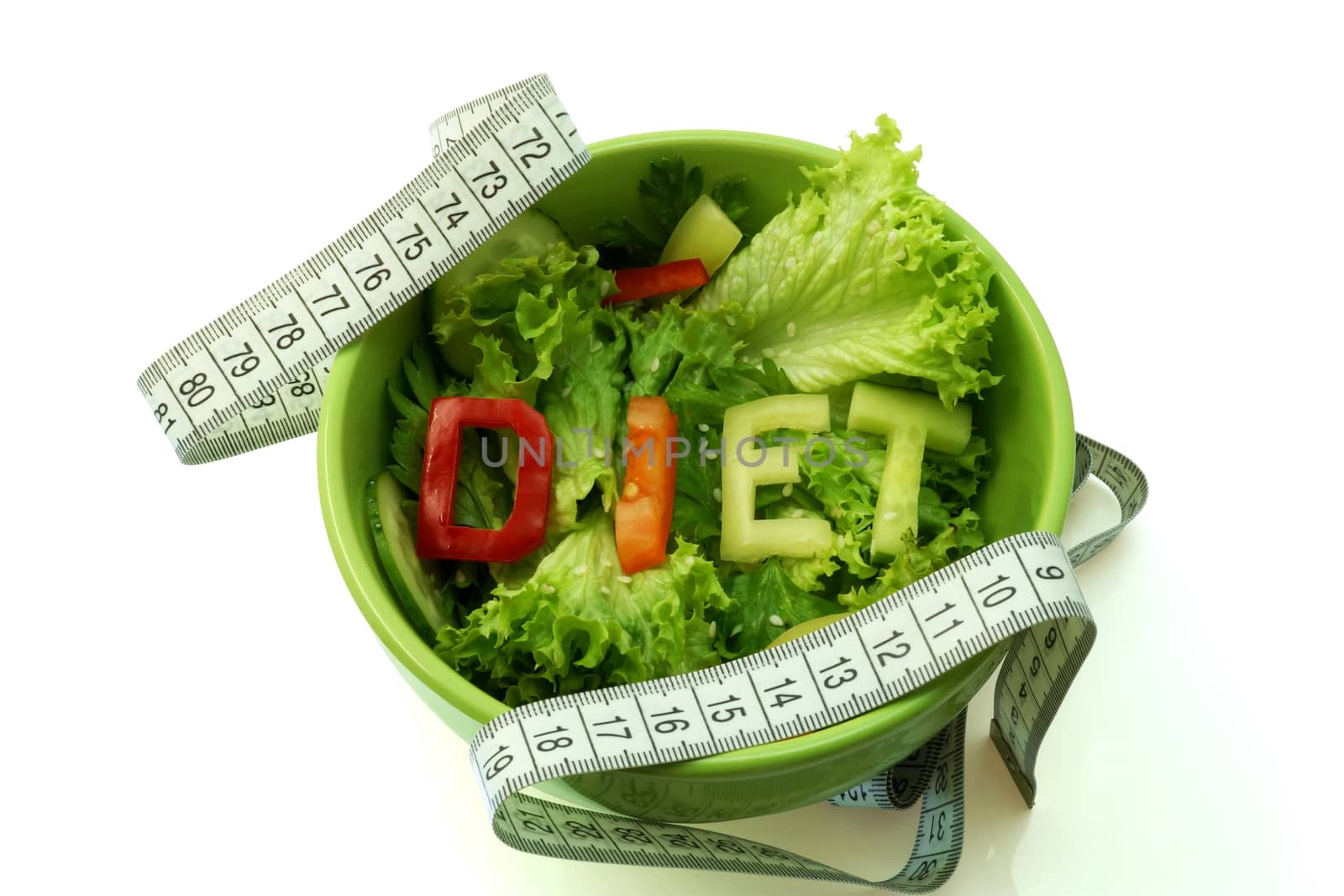 Green plate with word diet composed of slices of different vegetables on salad