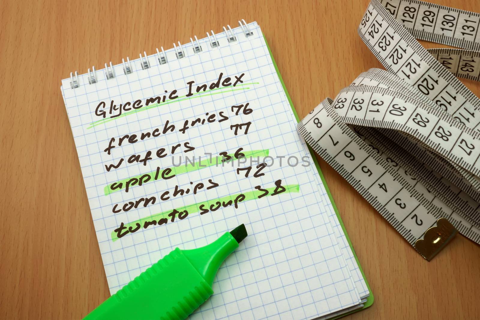 Measuring tape, a marker and a notepad with a glycemic index