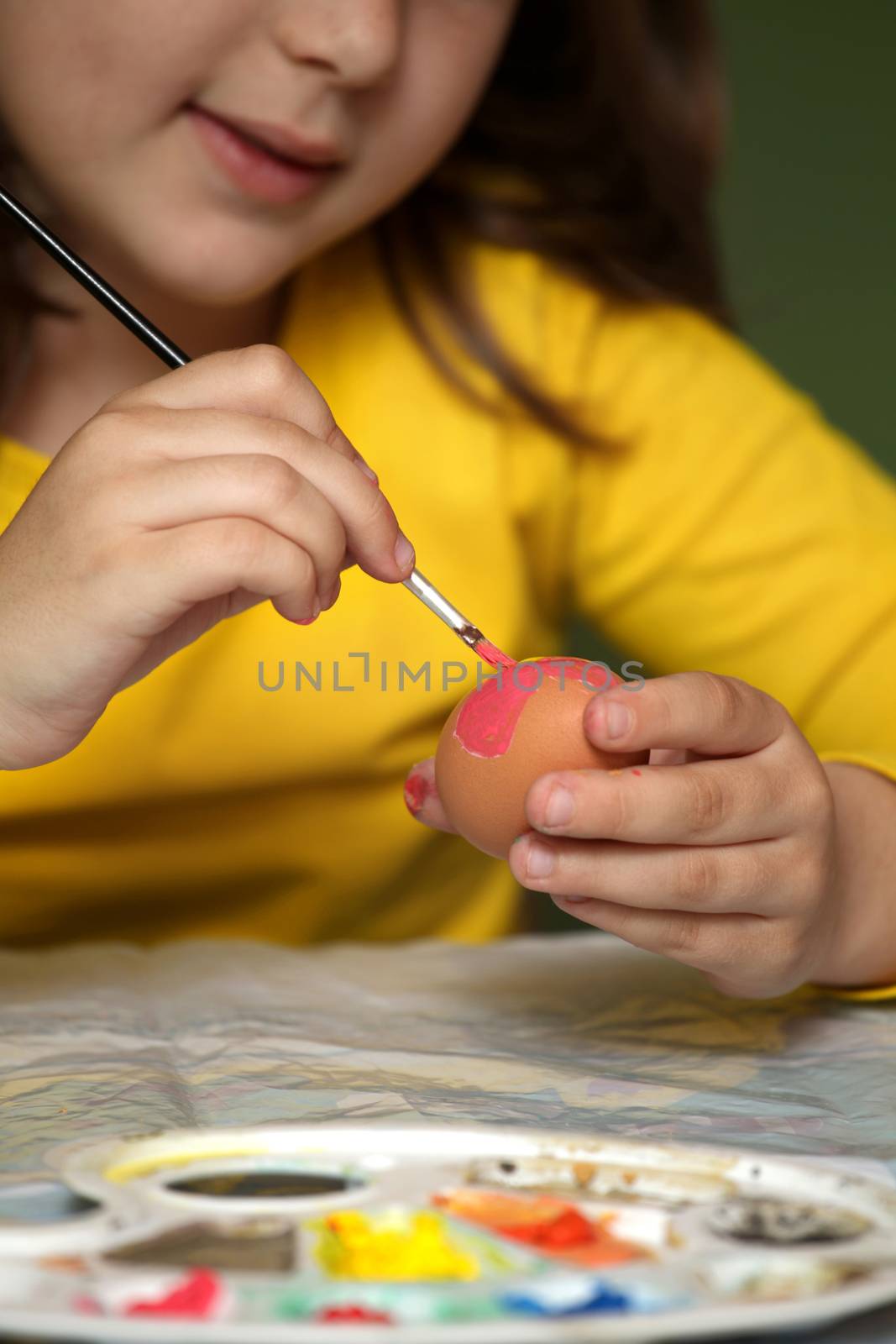 Girl painted Easter eggs at the table