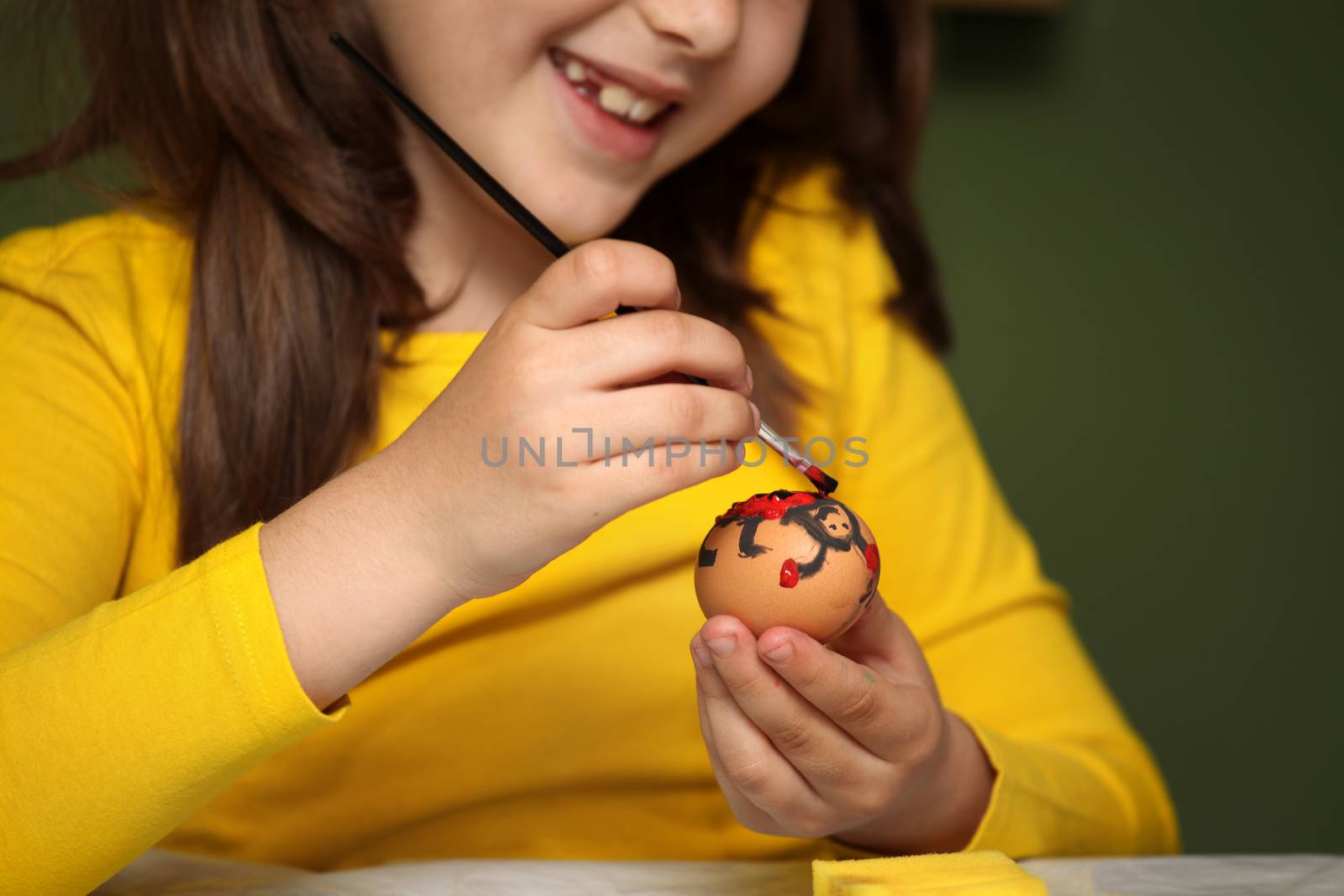 Girl painted Easter eggs at the table