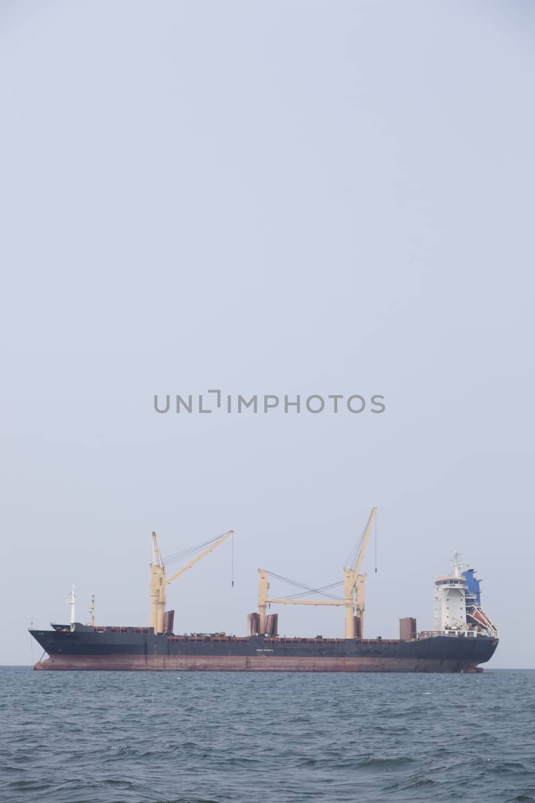 Large cargo ship Boats moored in the sea to make sense compared to the coast.