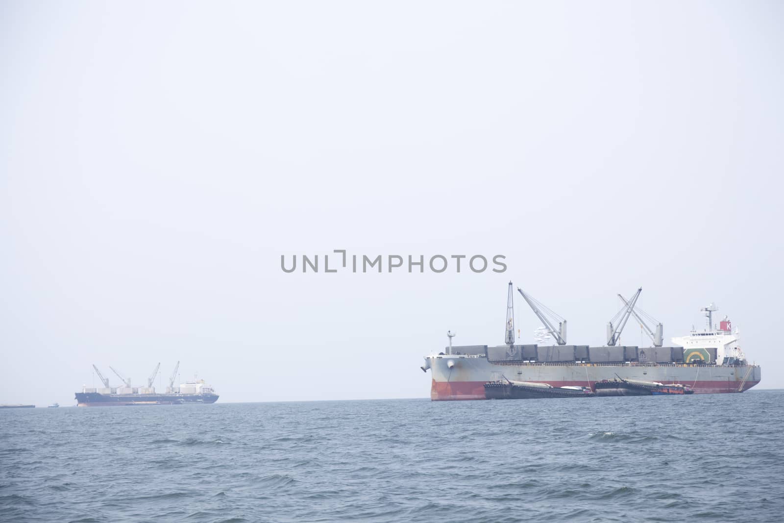 Large cargo ship Boats moored in the sea to make sense compared to the coast.