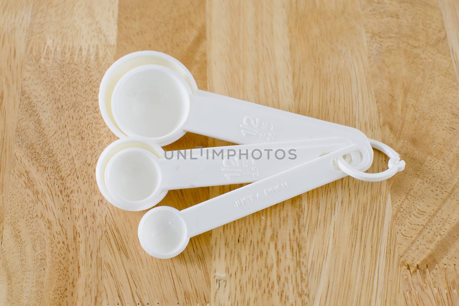 measuring spoons baking utensils ona wood background