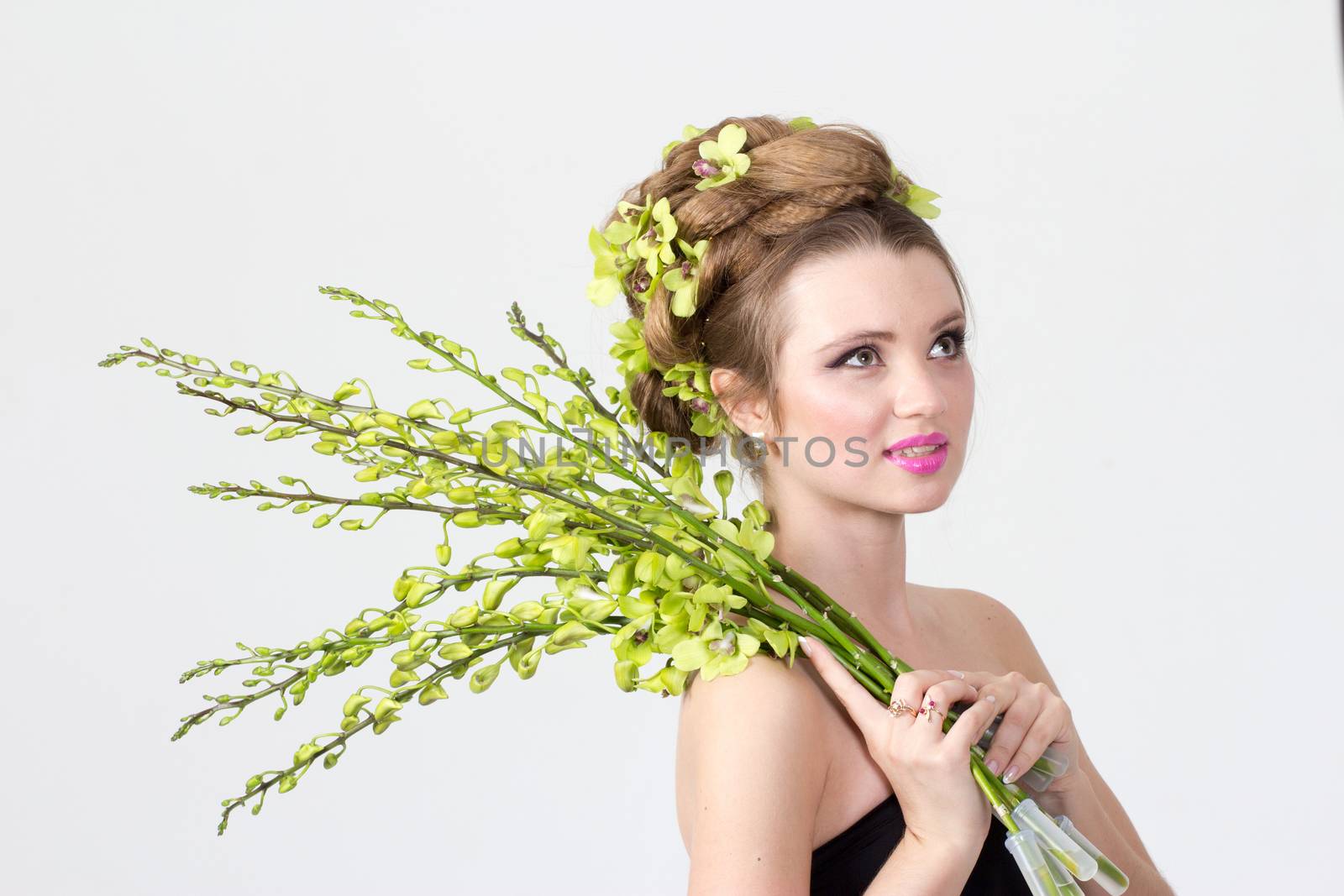 Beautiful woman with orchid flower in hair posing